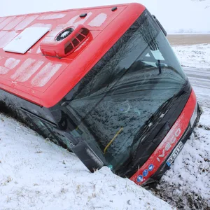 Roter Bus im verschneiten Straßengraben