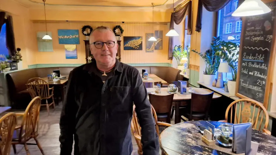 Ein Gastwirt steht in den Räumen einer Gastronomie.