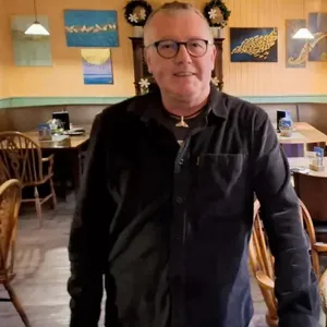 Ein Gastwirt steht in den Räumen einer Gastronomie.