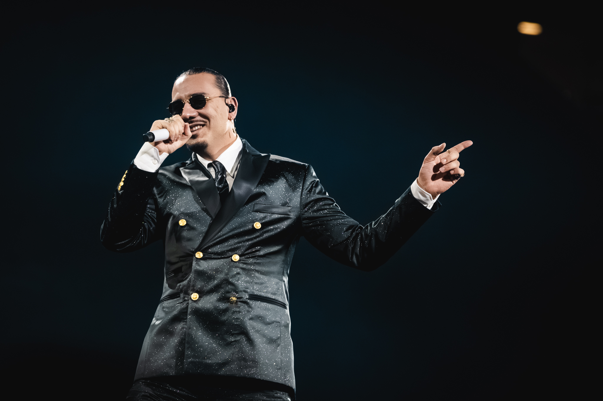 Er hat das Mikro vor dem Mund, man sieht, wie er lächelt