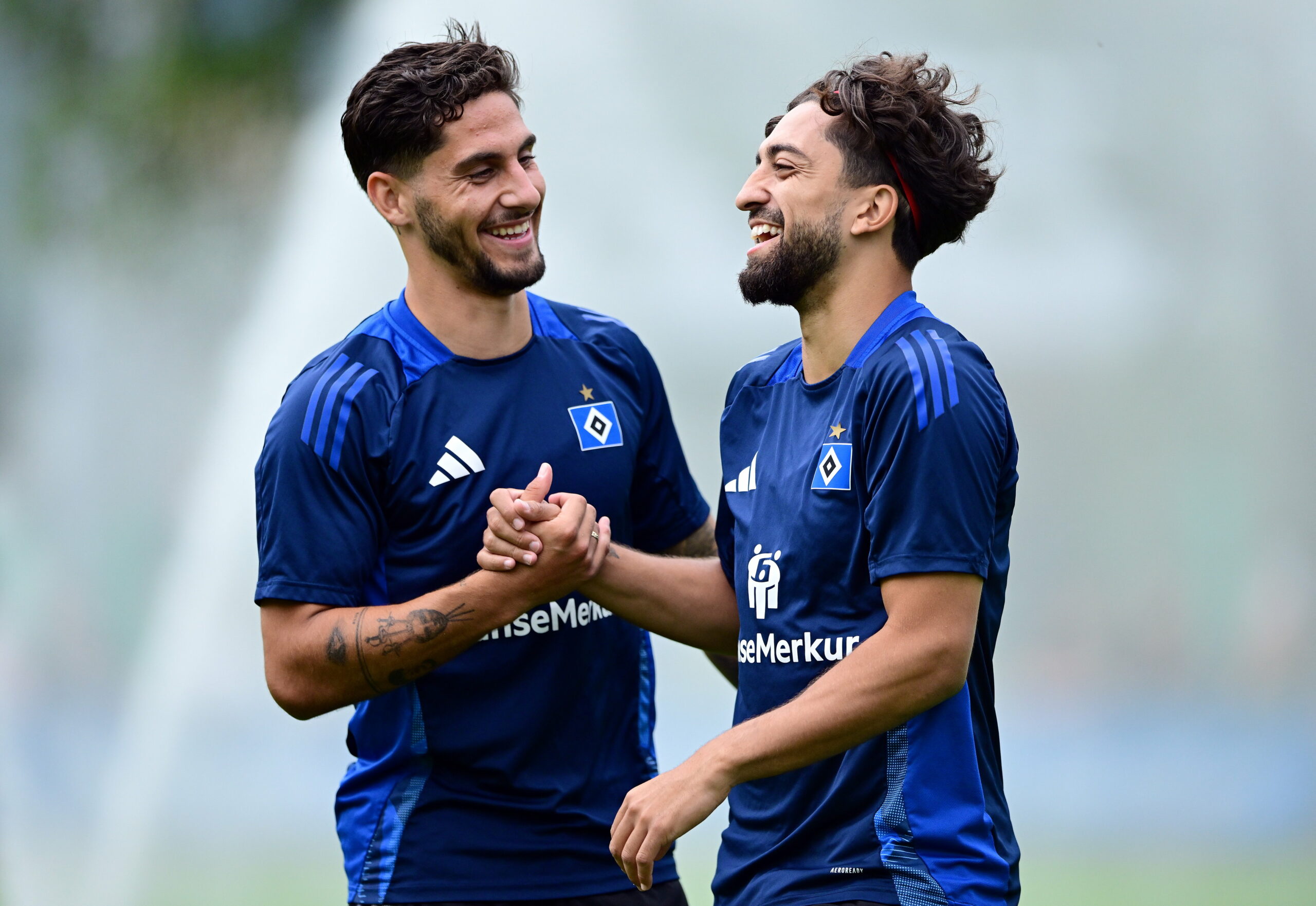 Ludovit Reis und Immanuel Pherai lachen gemeinsam auf dem Trainingsplatz.