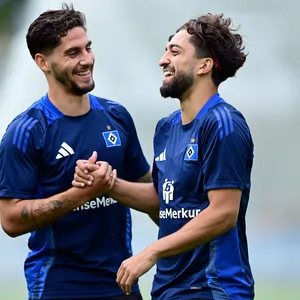 Ludovit Reis und Immanuel Pherai lachen gemeinsam auf dem Trainingsplatz.