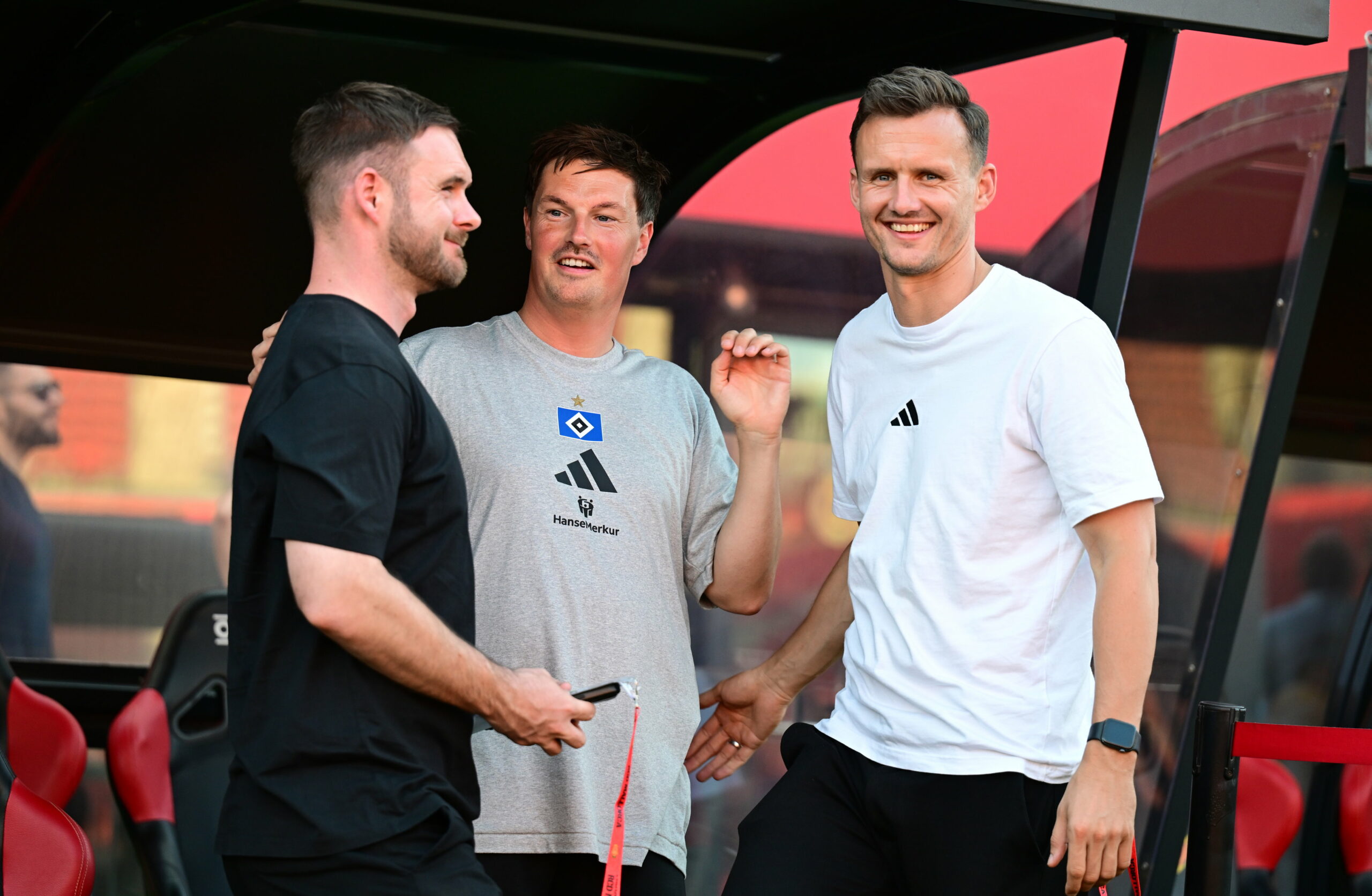 Sebastian Dirscherl, Merlin Polzin und Claus Costa lachen am Trainingsplatz
