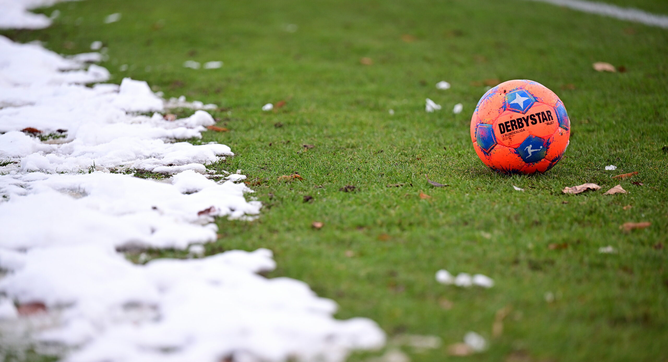 Ball liegt auf schneebedecktem Fußball-Platz