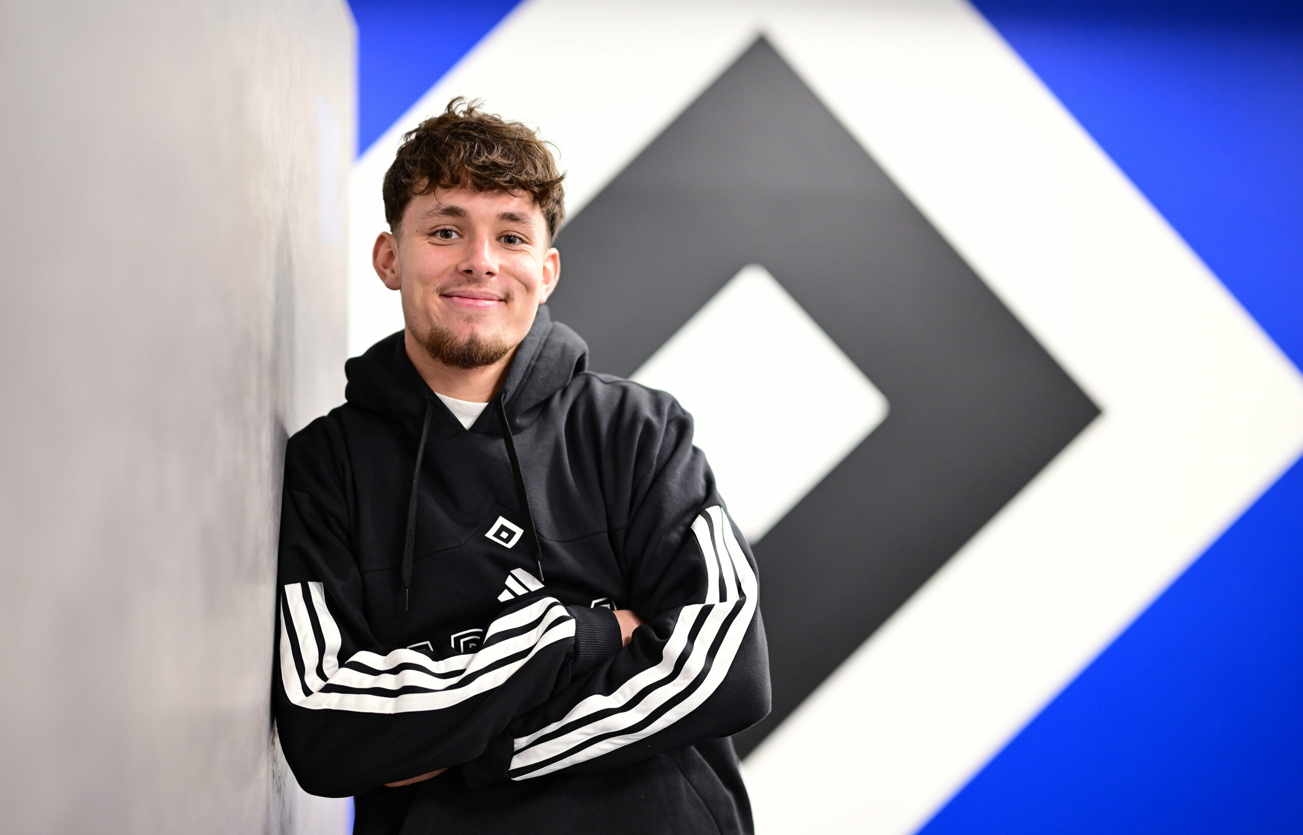 Otto Stange lächelt, im Hintergrund ist die HSV-Raute zu sehen.