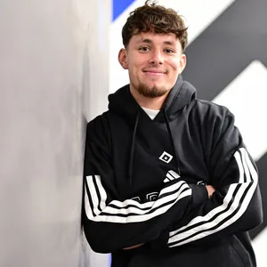 Otto Stange lächelt, im Hintergrund ist die HSV-Raute zu sehen.