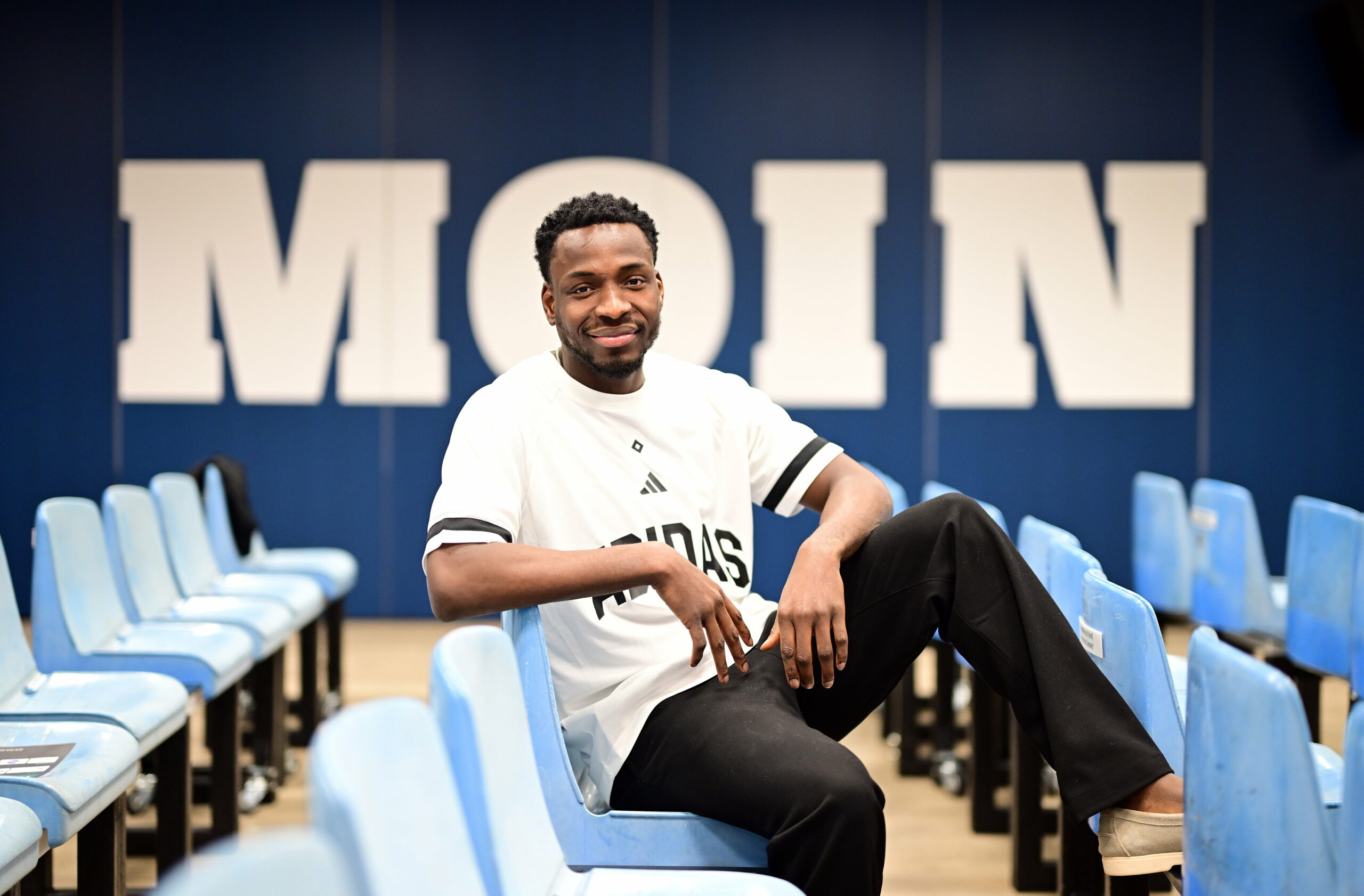 Philip Otele im HSV-Dress vor einer Moin-Wand