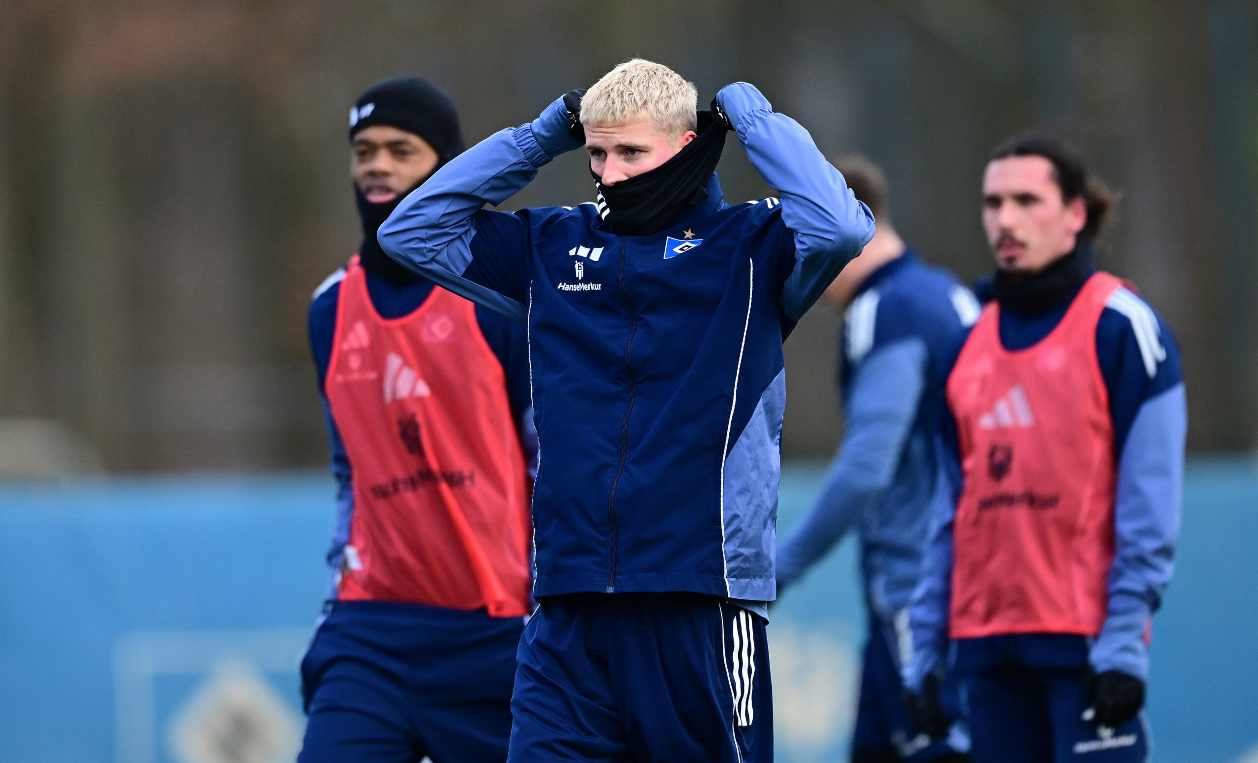 Albert Grønbæk schützt sich auf dem Trainingsplatz mit einem Schal vor der Kälte. .