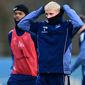 Albert Grønbæk schützt sich auf dem Trainingsplatz mit einem Schal vor der Kälte. .