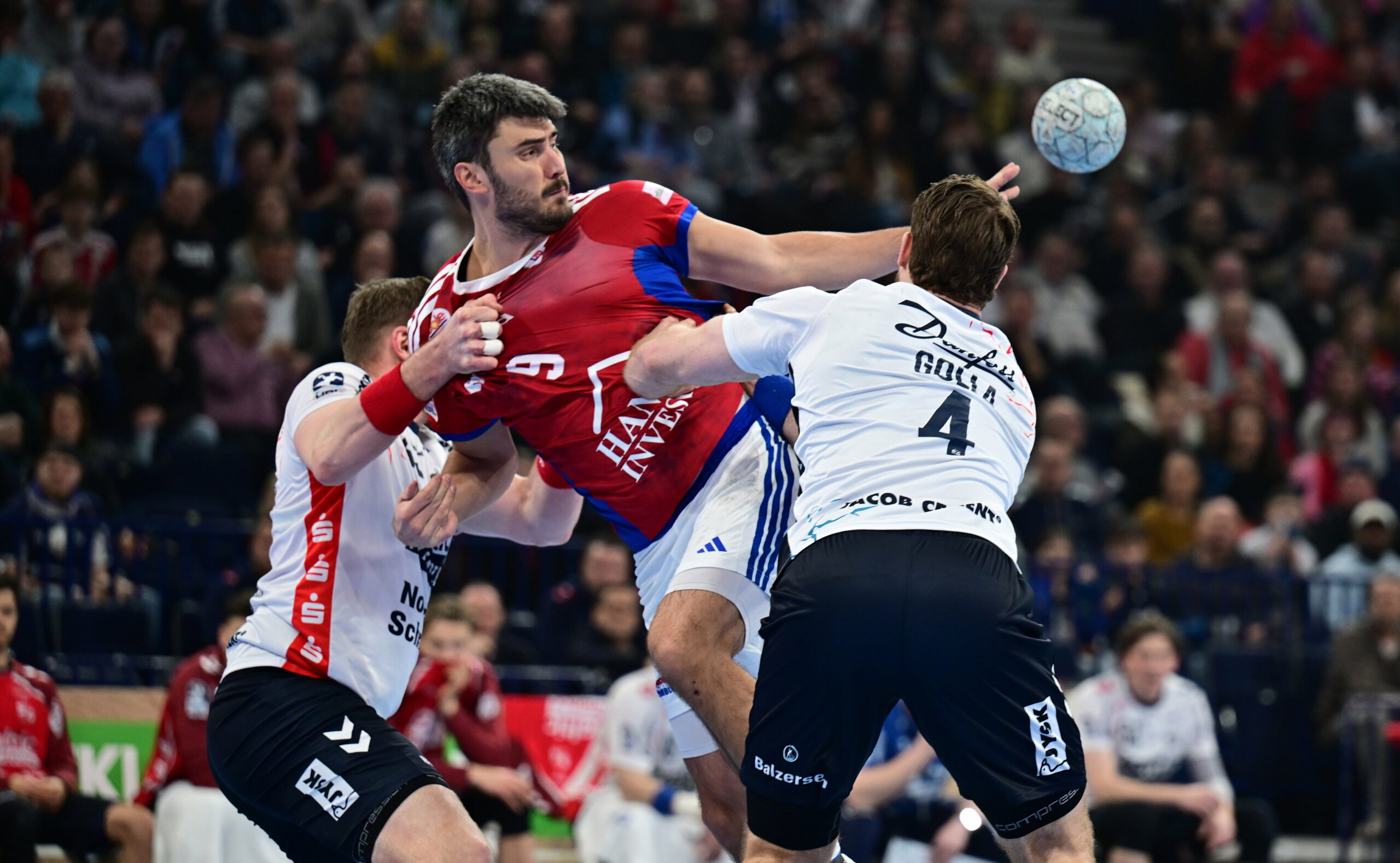 Jacob Lassen vom HSV Hamburg wird von zwei Flensburger Gegenspielern gestoppt