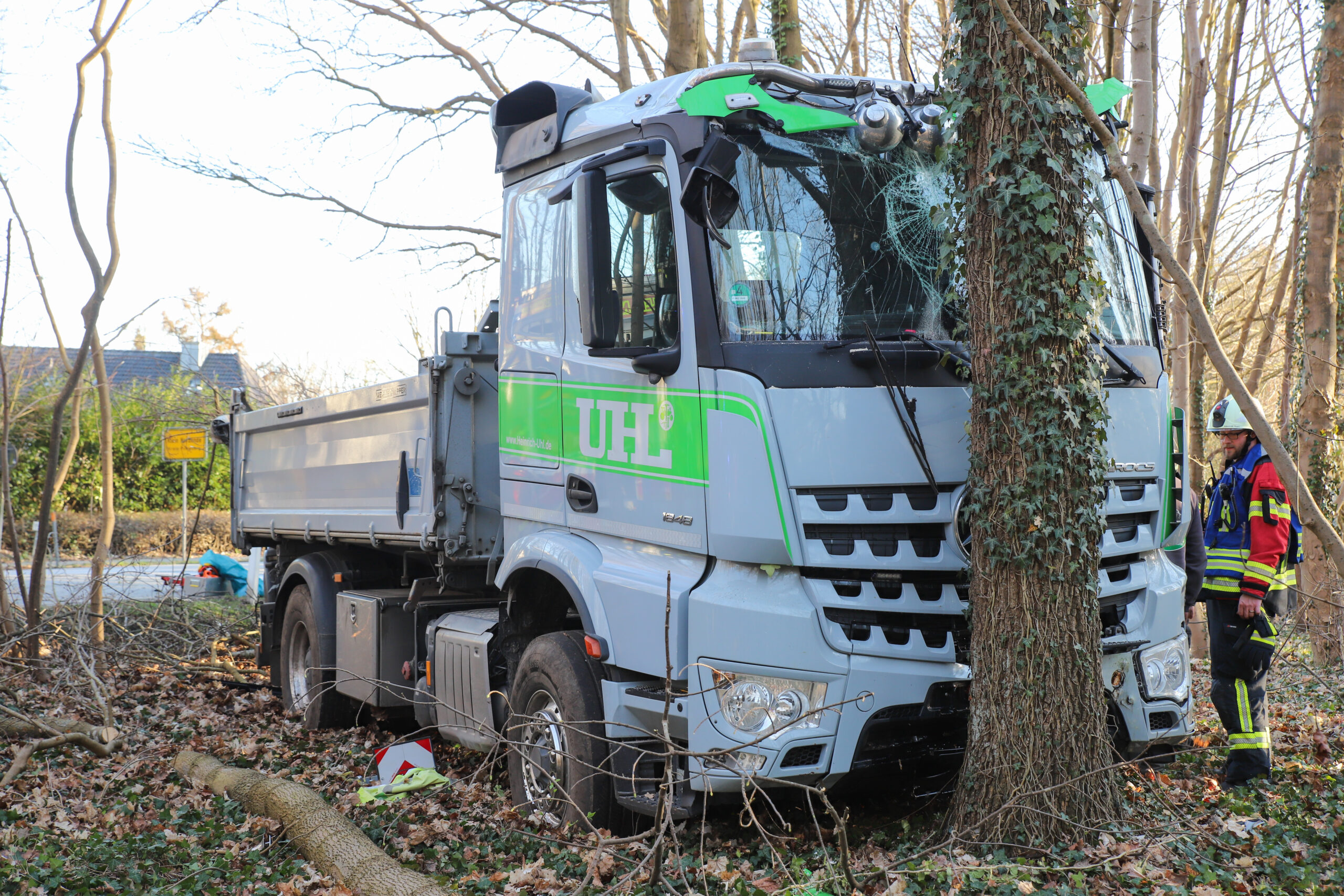 Ein Lkw steht mit zersplitterte Scheibe vor einem Baum.