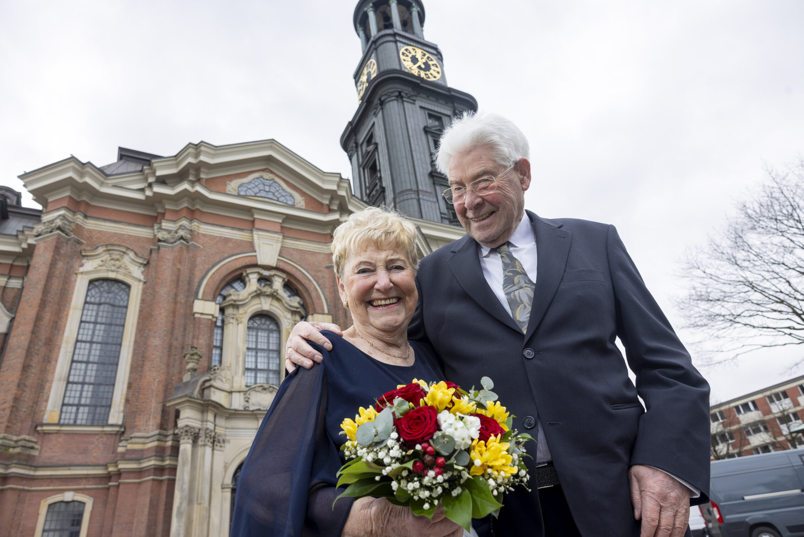 Älteres Paar mit Blumenstrauß vor dem Michel