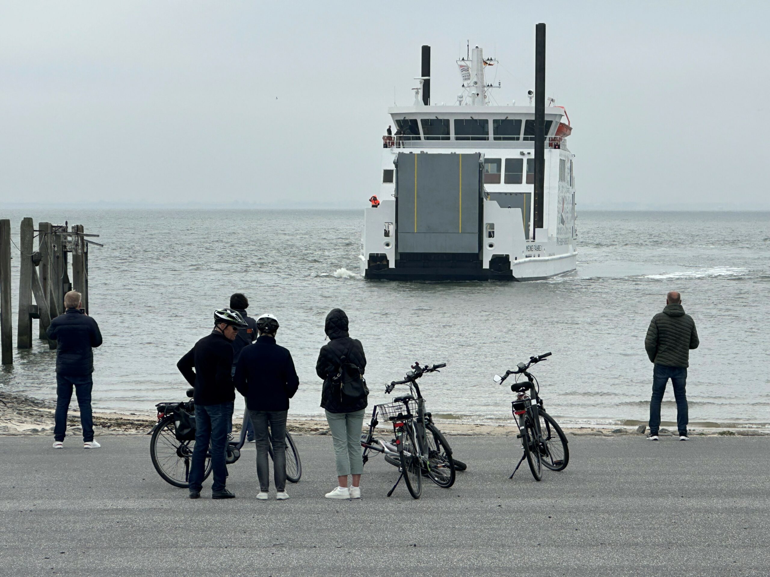 Passanten beobachten, wie das Schiff „Meine Fähre 1“ an der ostfriesischen Insel Norderney anlegt.