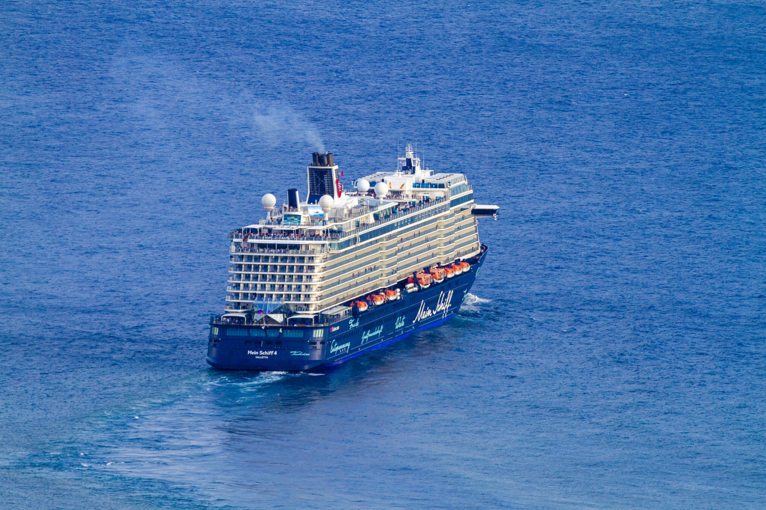 „Mein Schiff 4“ von TUI Cruises fährt bei gutem Wetter über das Meer.