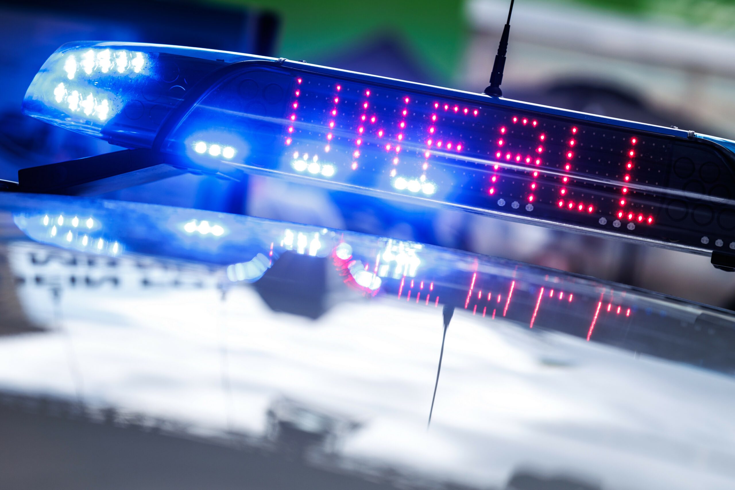 Das eingeschaltete Blaulicht mit der Leuchtschrift „Unfall“ auf einem Polizeiwagen