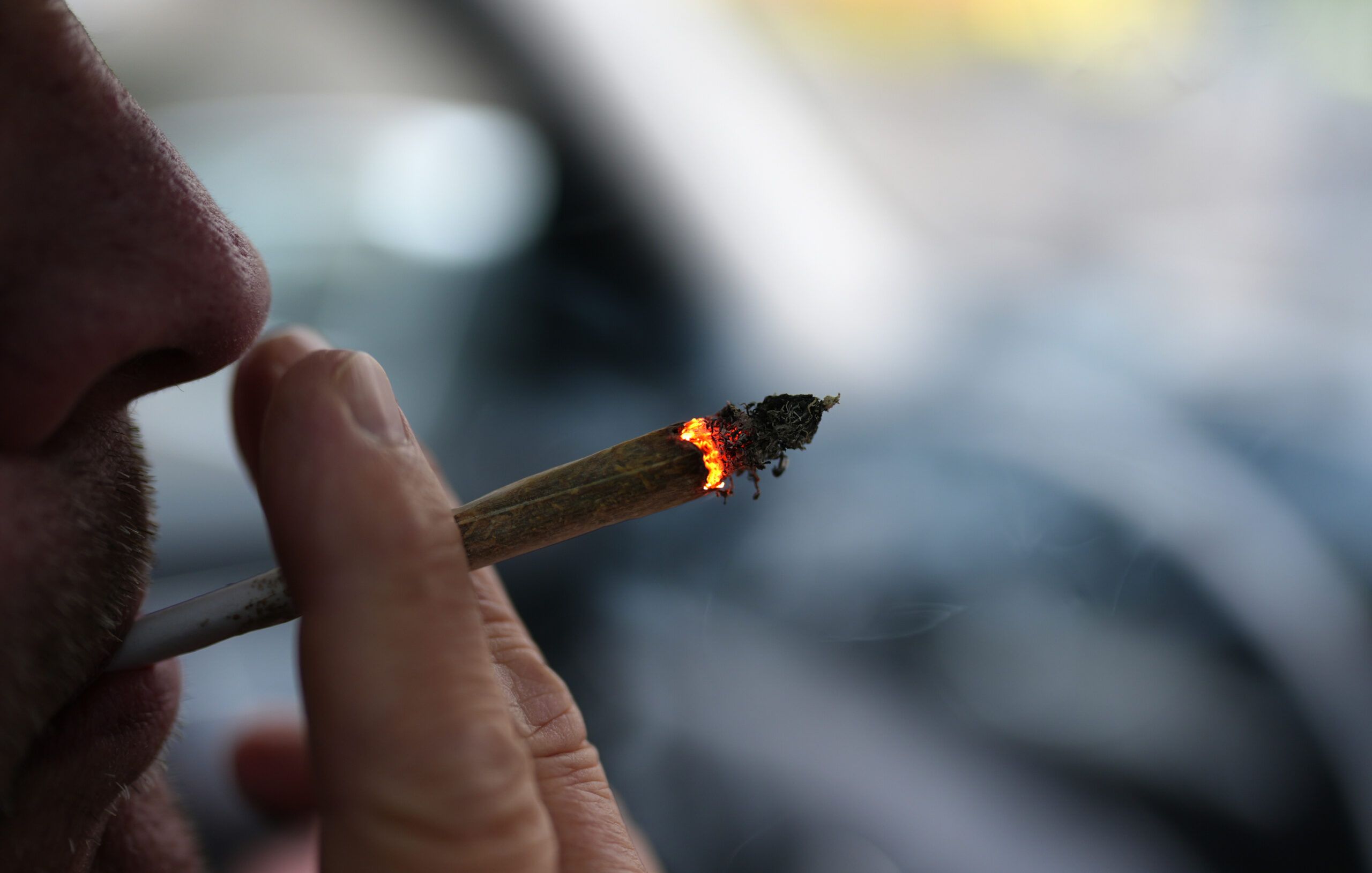 Ein Mann raucht einen Joint.