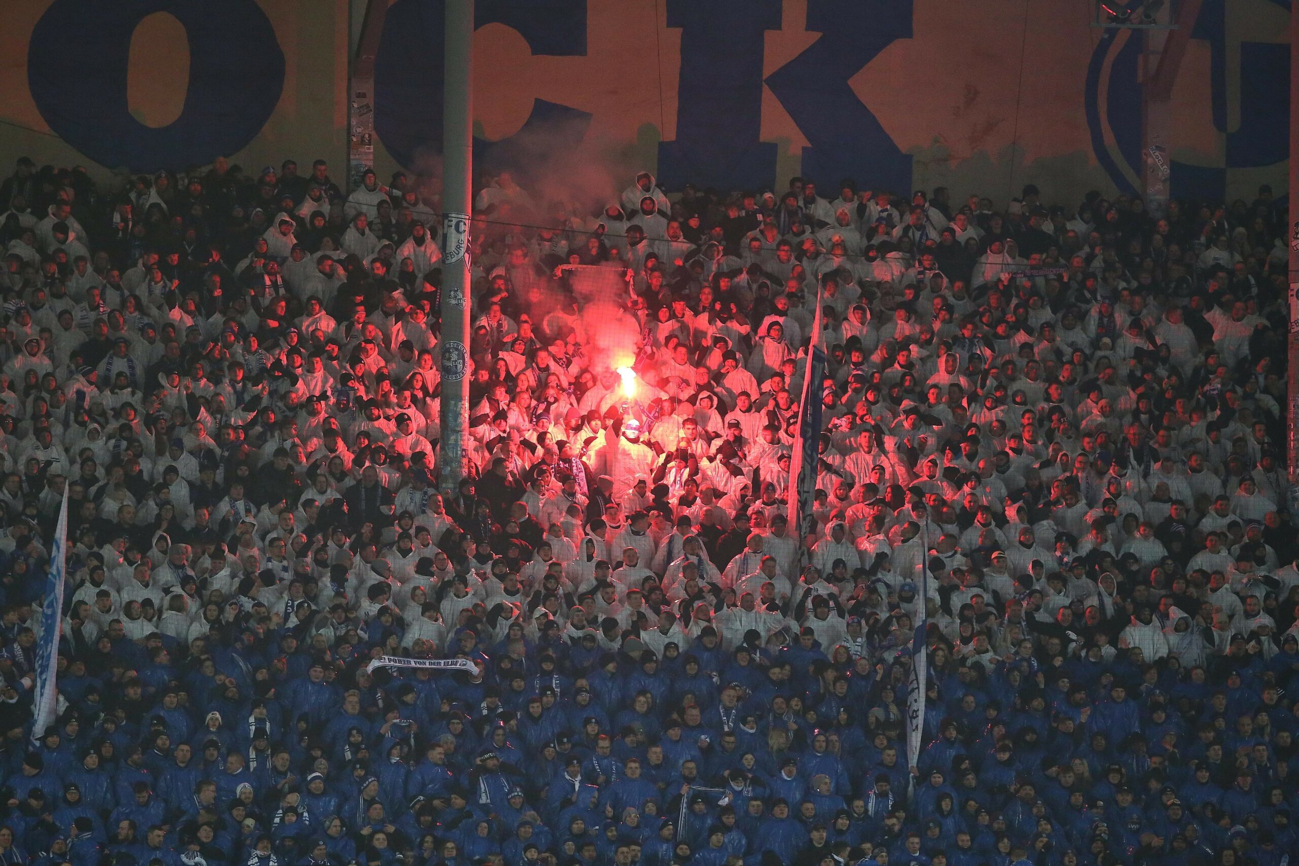 Fans des 1. FC Magdeburg mit einer Choreographie und Pyrotechnik im Block.