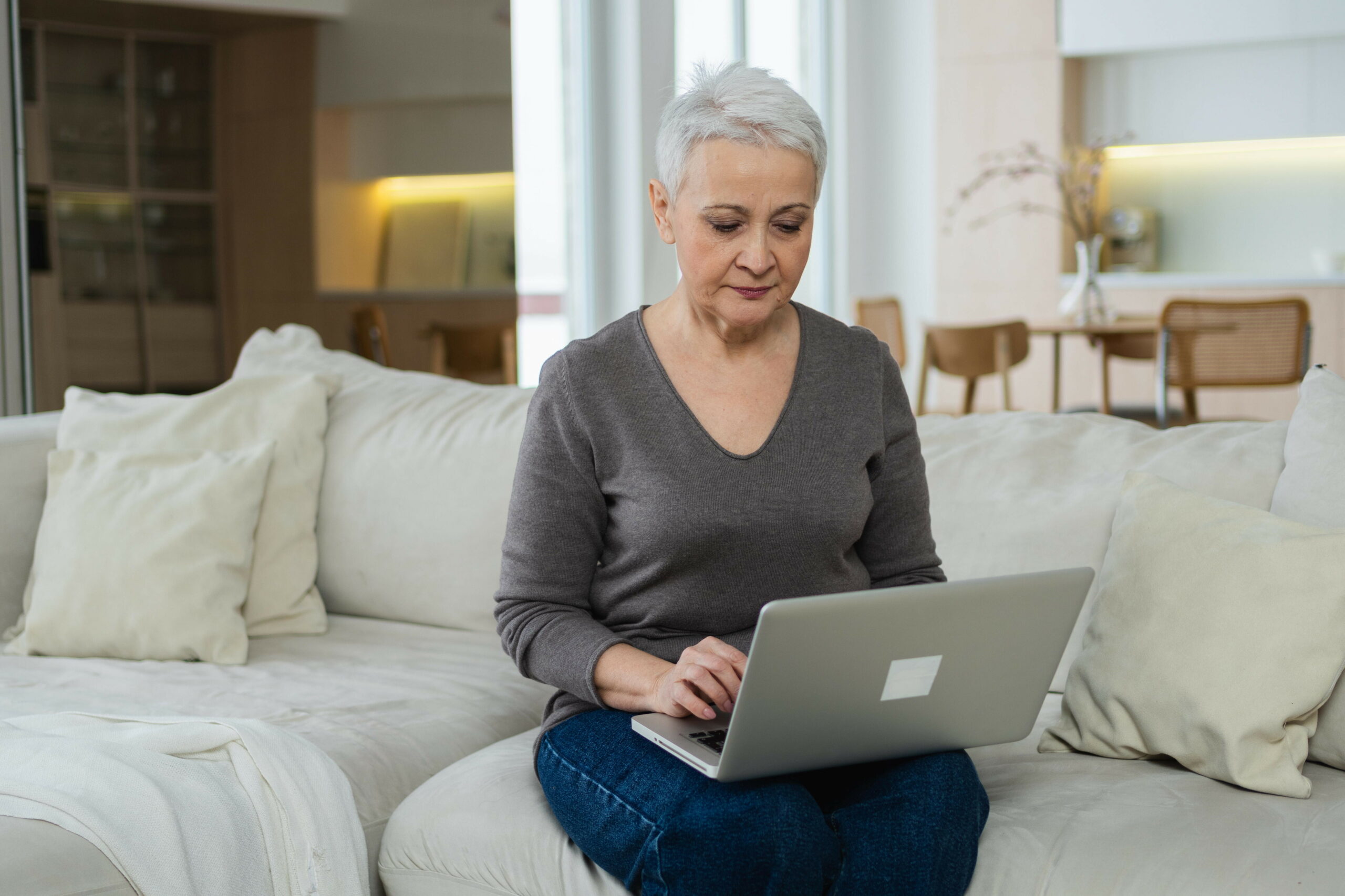 Eine Rentnerin sitzt am Laptop.