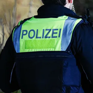 Aufschrift "Polizei" auf schusssicherer Weste von Polizisten mit Landeswappen von Schleswig-Holstein