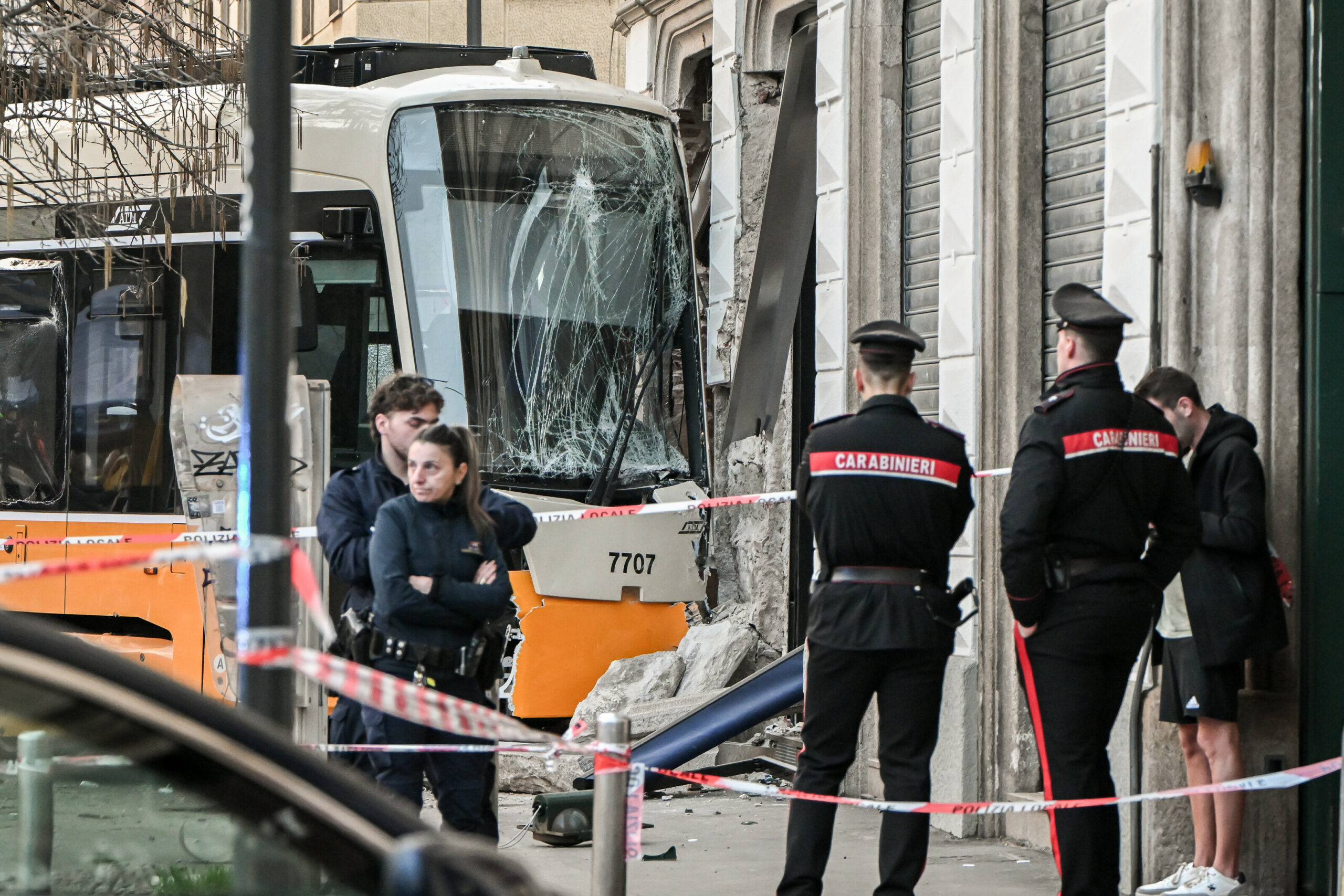 Polizisten stehen am Unfallort vor der verunglückten Straßenbahn.