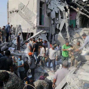 Rettungskräfte und Anwohner durchsuchen die Trümmer nach einem Angriff auf eine Grundschule für Mädchen.