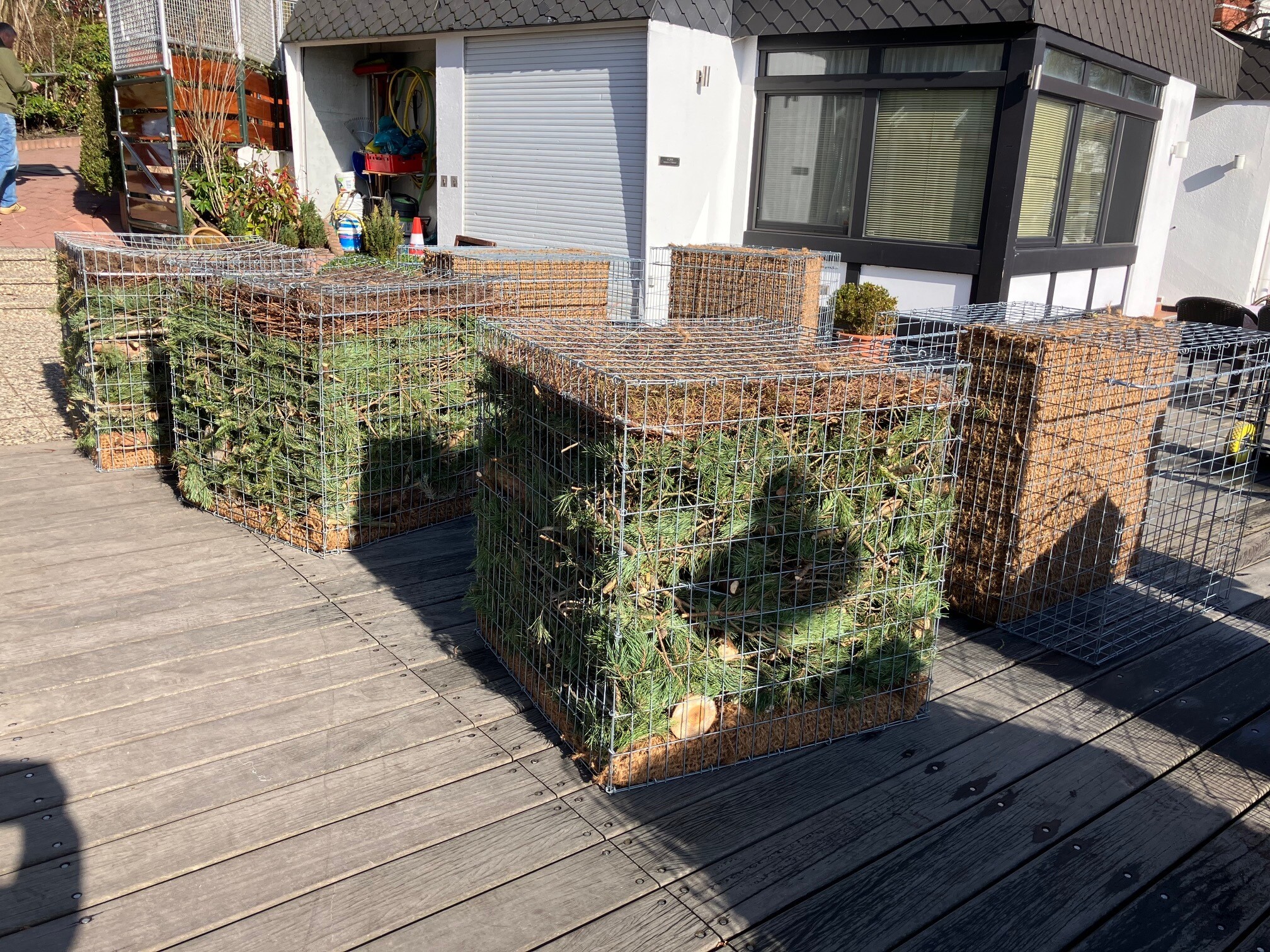 Unter einem Segelsteg an der Außenalster werden mit Naturmaterial gefüllte Metallkisten versenkt.