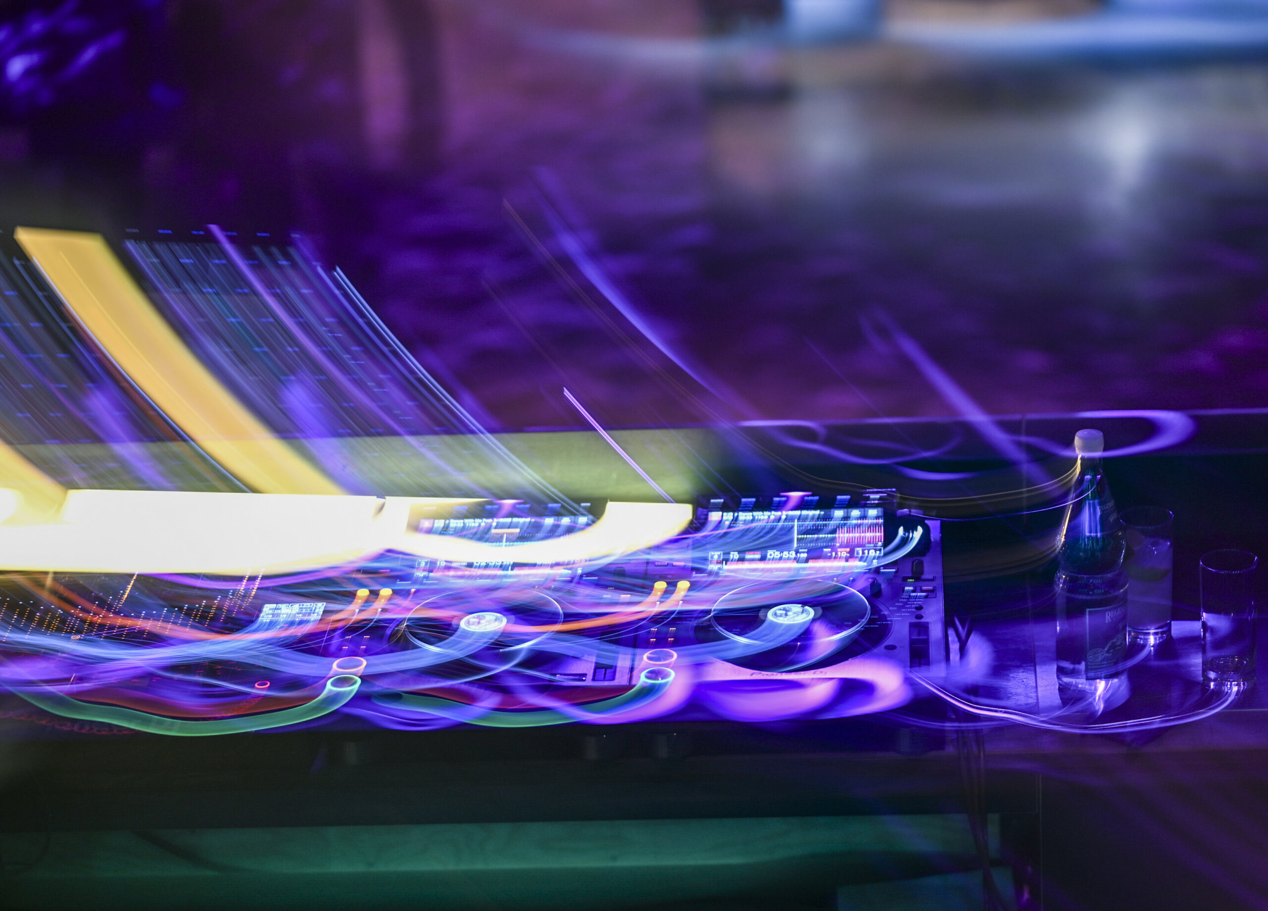 Ein DJ-Pult leuchtet bei einer Feier im Dunkeln (Symbolfoto).