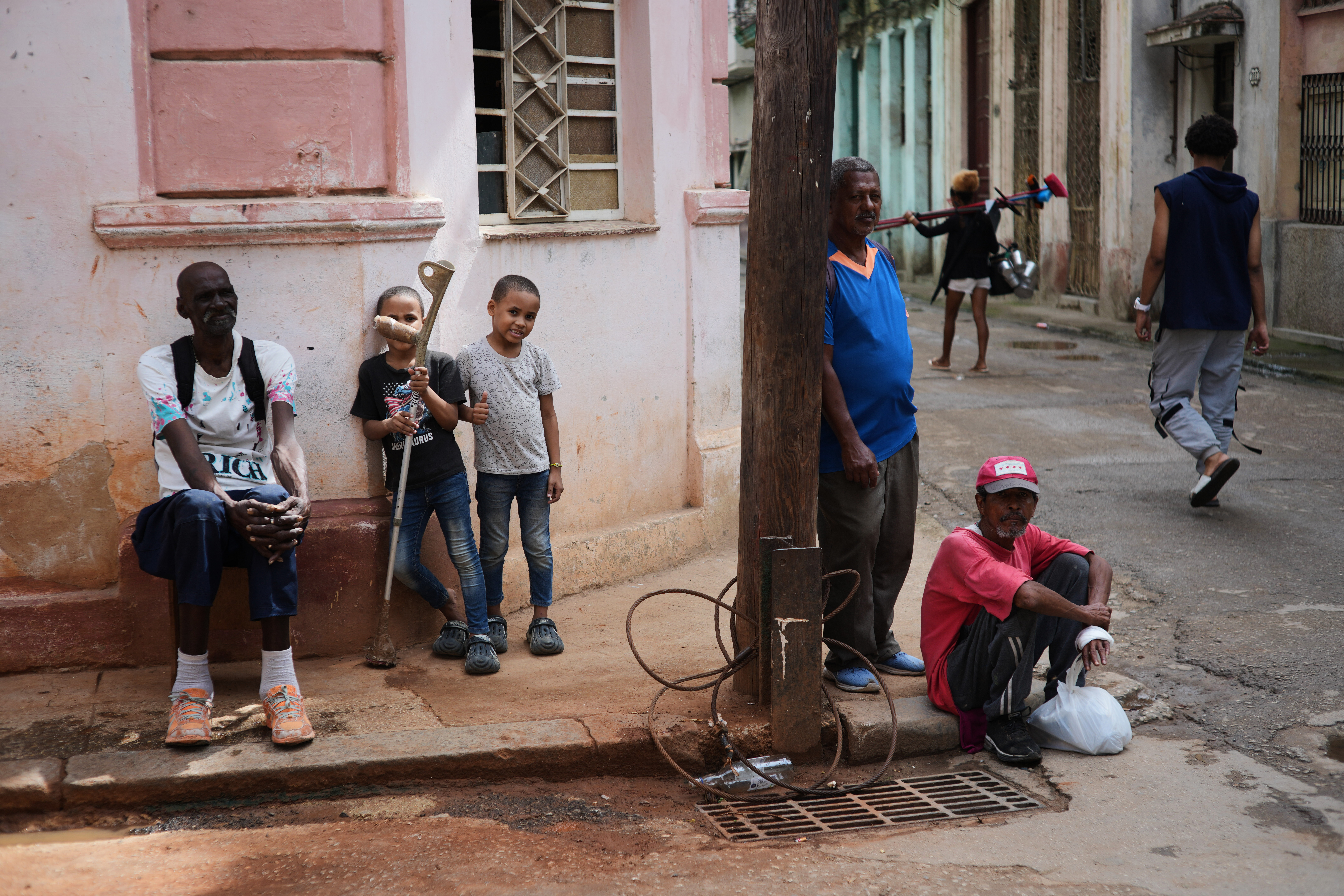 Menschen sitzen während eines Stromausfalls in Havanna, Kuba auf dem Bürgersteig.