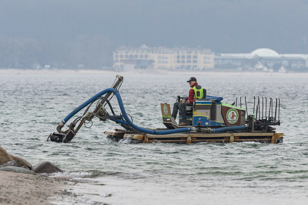 Ein Mann sitzt auf einem Saugbagger in der Ostsee