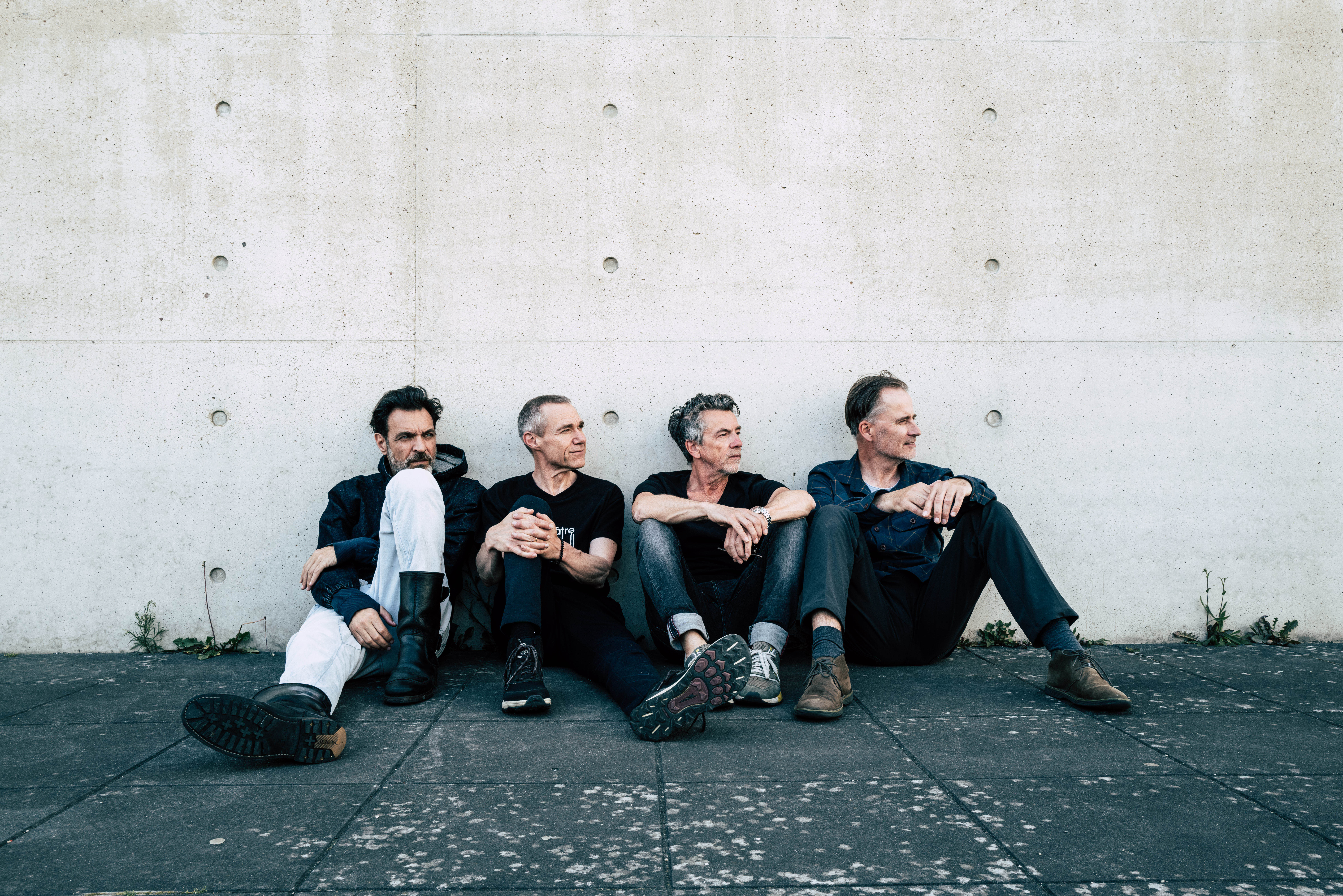 The Jeremy Days sitzen an eine Wand gelehnt auf dem Boden.