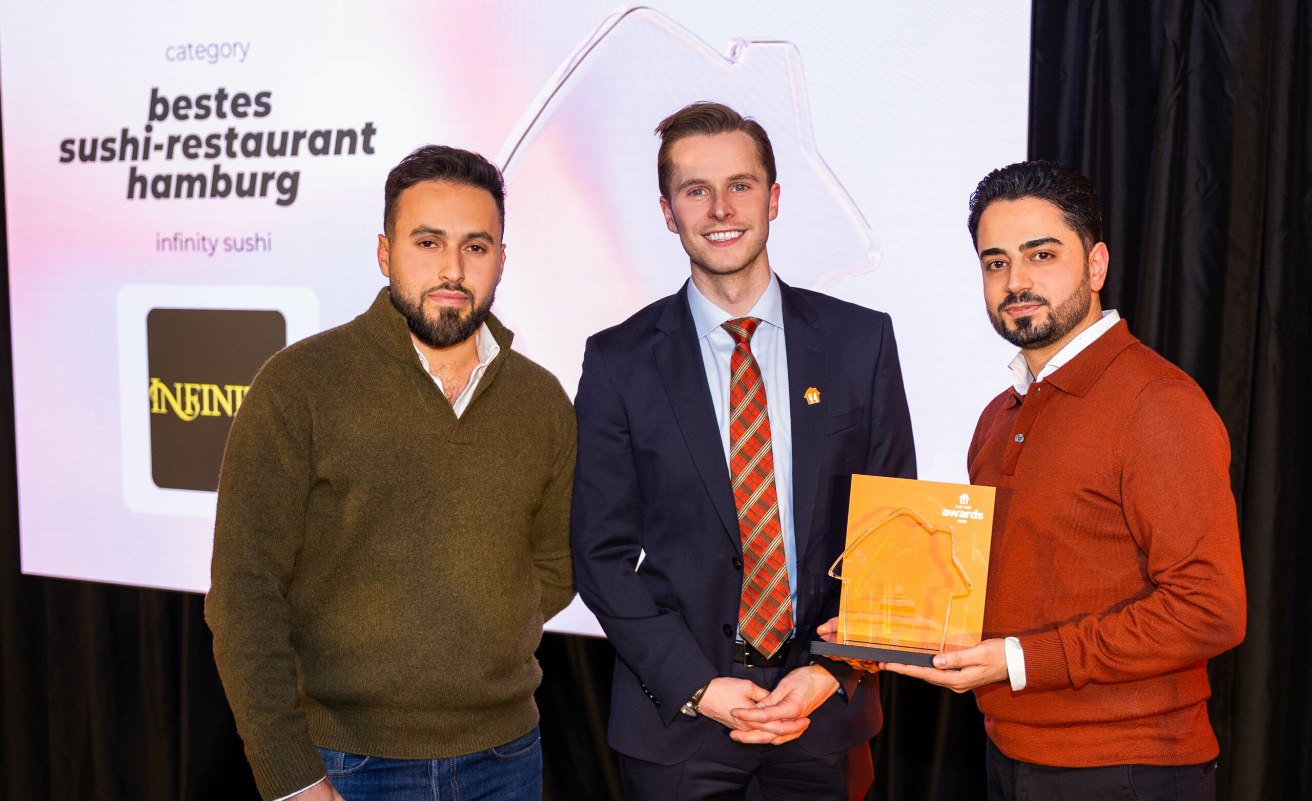 Zwei Männer nehmen den Preis vom Lieferando-Award entgegen.