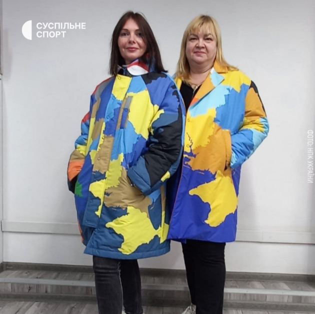 Zwei Frauen posieren in Mänteln. die die Landkarte der Ukraine aus dem Jahr 1991 abbilden.