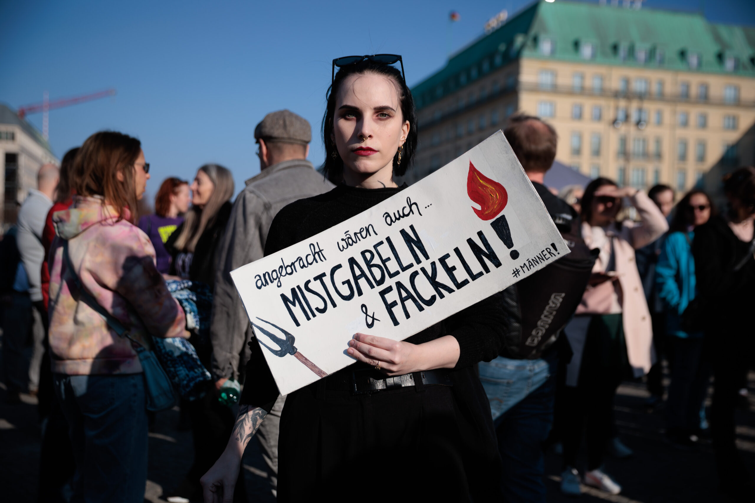 Eine Teilnehmerin hält ein Schild mit der Aufschrift «angebracht wären auch... Mistgabeln & Fackeln - #Männer» bei einer Demonstration gegen sexualisierte digitale Gewalt vor dem Brandenburger Tor.