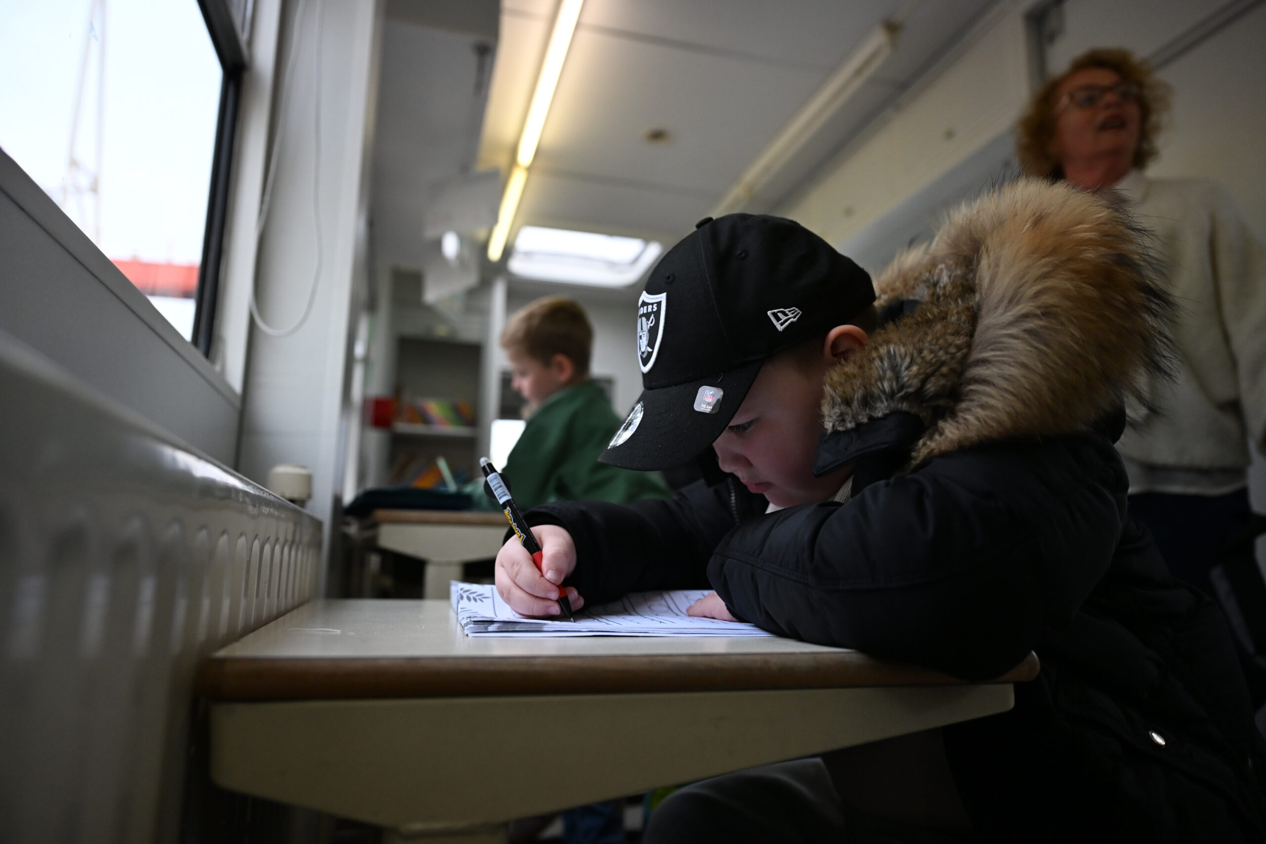 Milo (7) lernt einem Wagen, in dem die Kinder von Schaustellern Hausaufgabenhilfe bekommen.