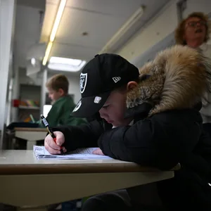 Milo (7) lernt einem Wagen, in dem die Kinder von Schaustellern Hausaufgabenhilfe bekommen.