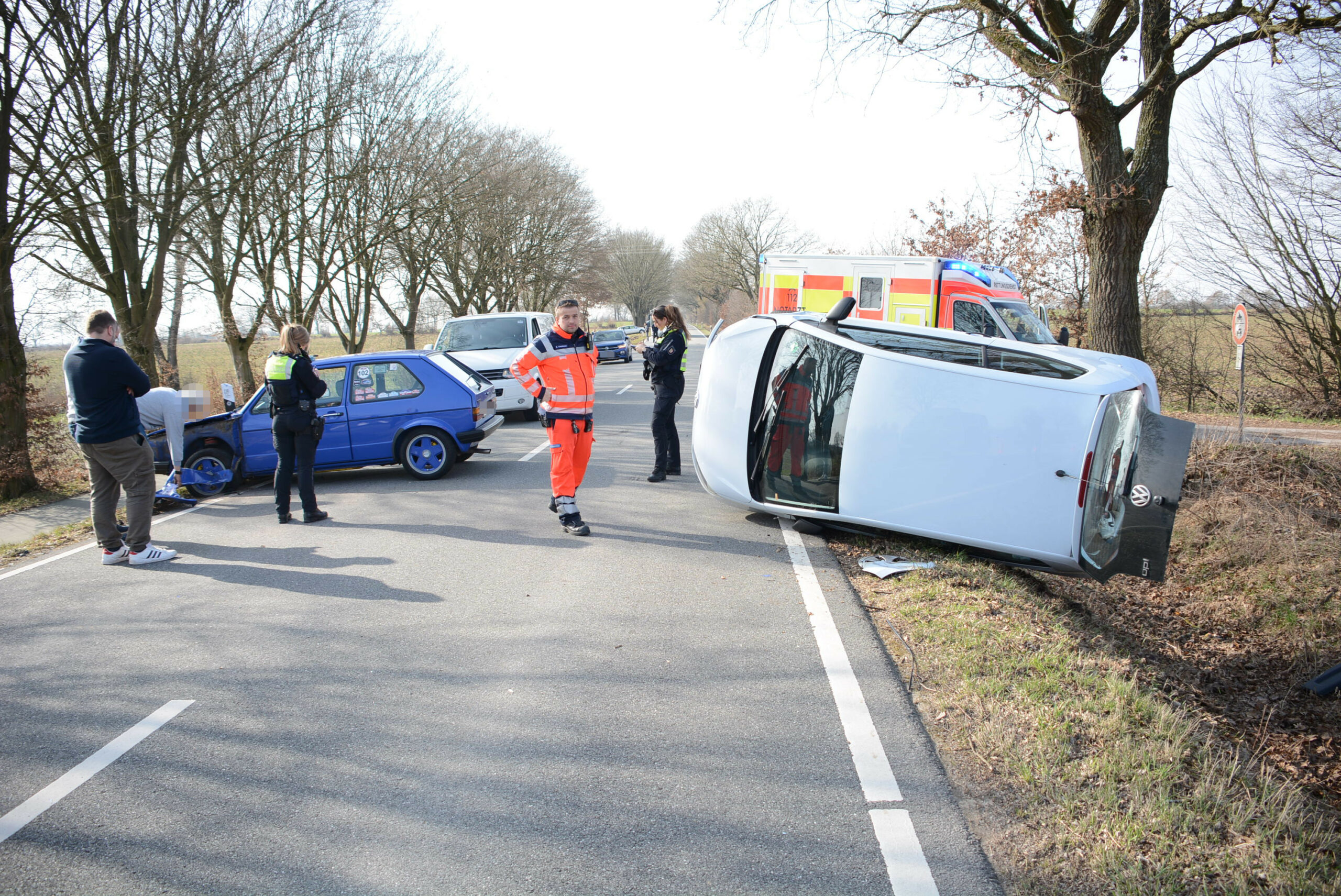 Ein Auto liegt seitlich in einem Straßengraben.