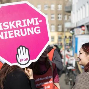 Demo für Frauenrechte, auf einem Schild steht Stop Diskriminierung