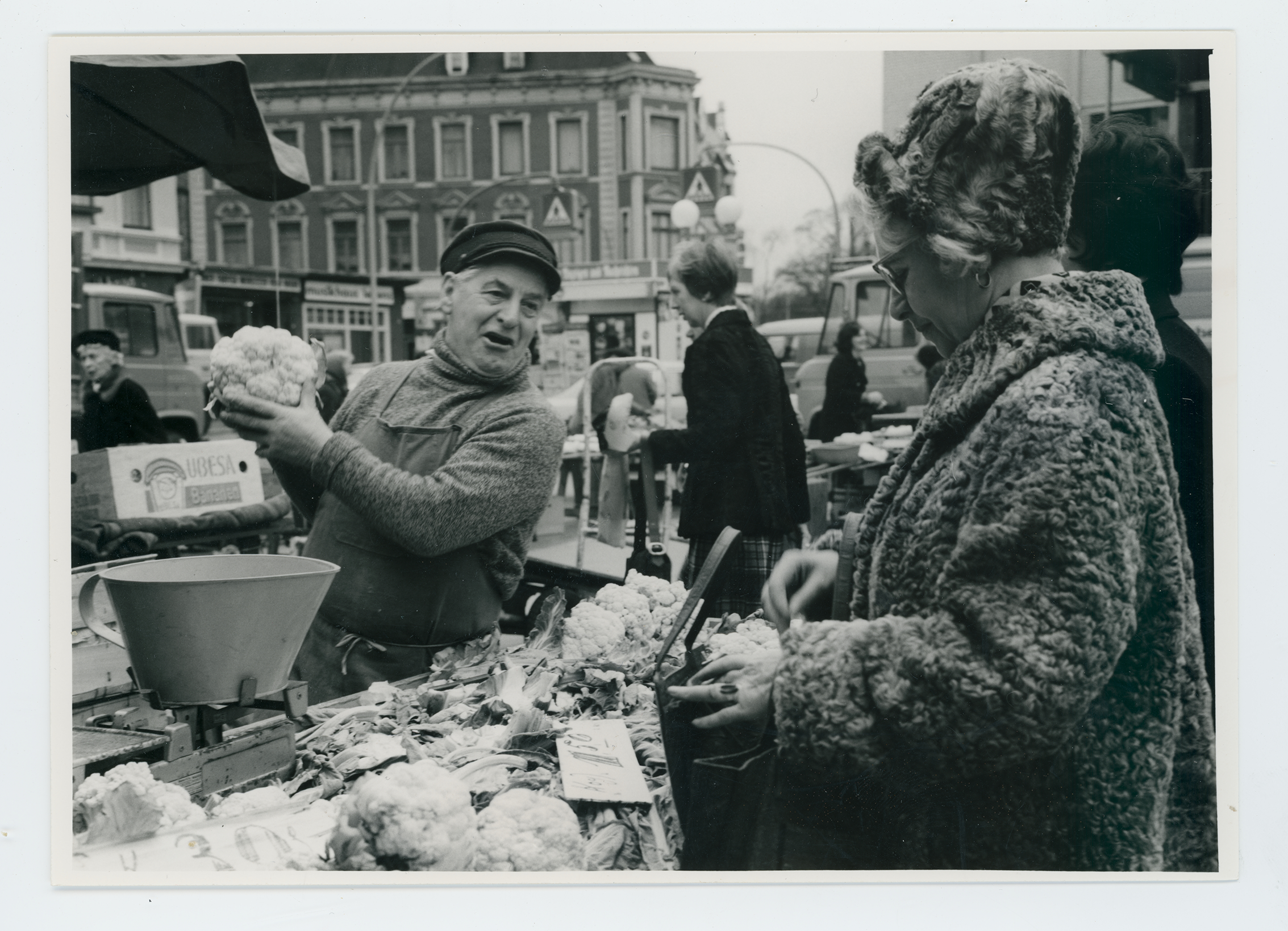 Ein Gemüsehändler auf einem Wochenmarkt