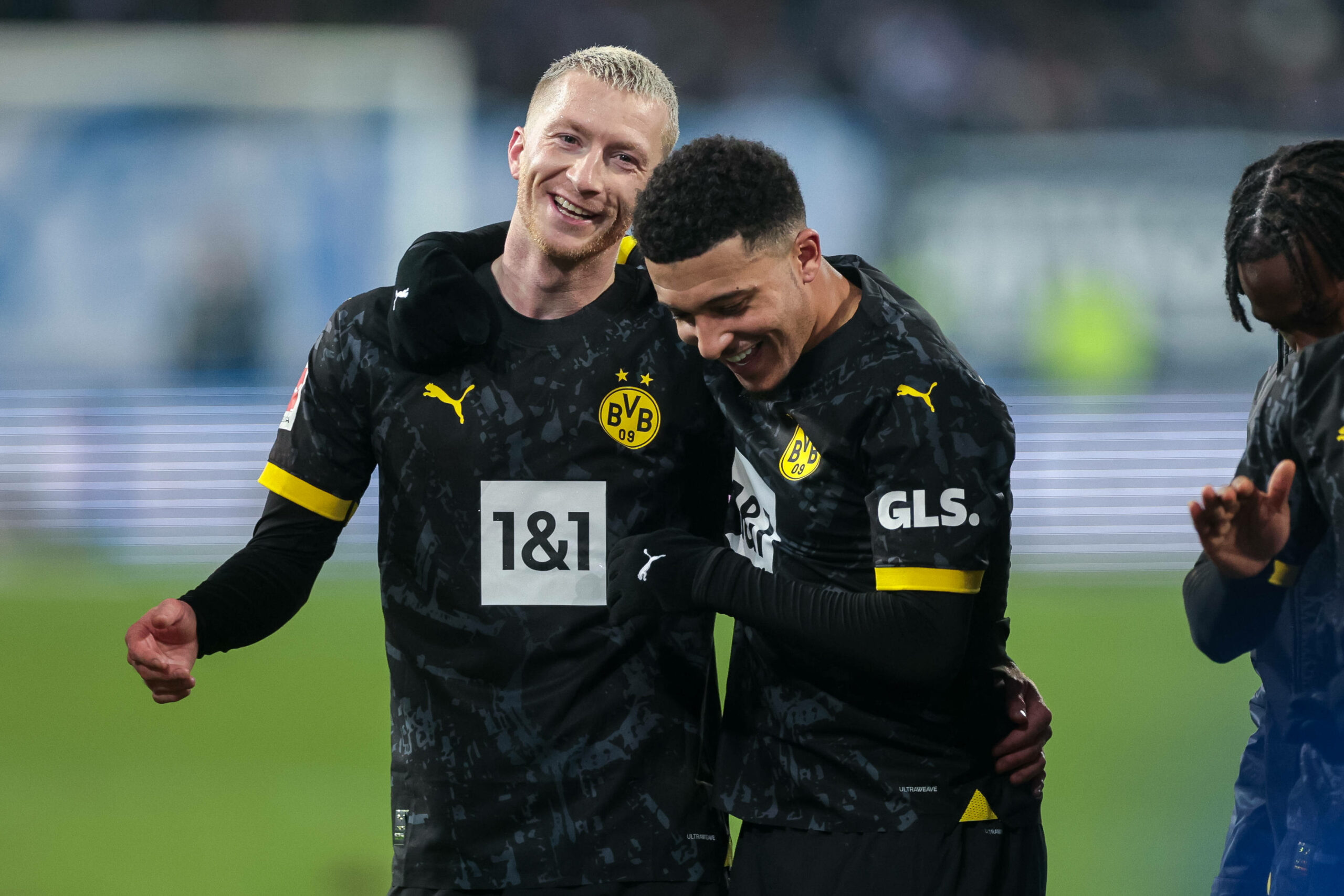 Marco Reus und Jadon Sancho umarmen sich lachend