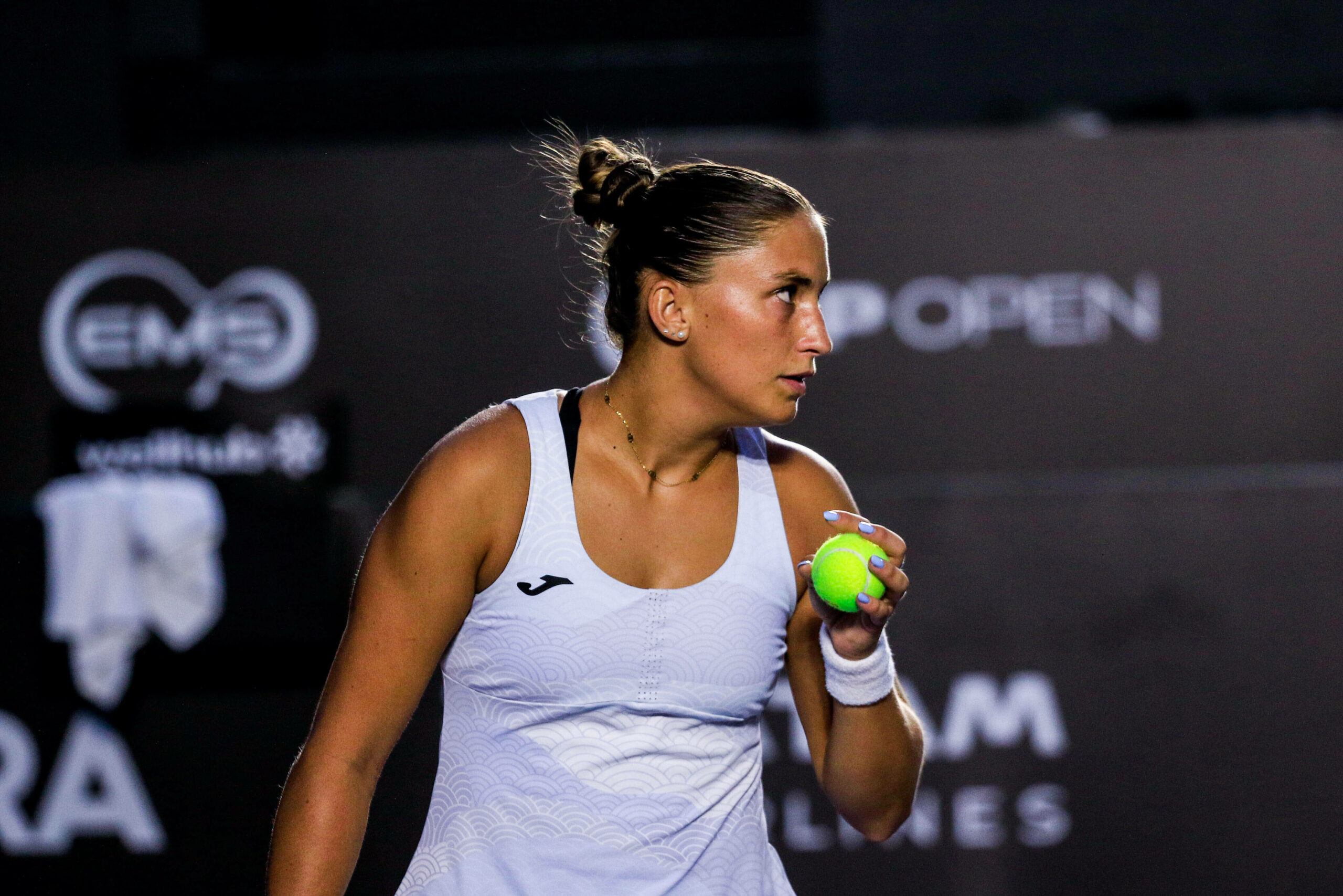 Panna Udvardy hält einen Tennisball in der linken Hand und schaut konzentriert bei einem Tennis-Match