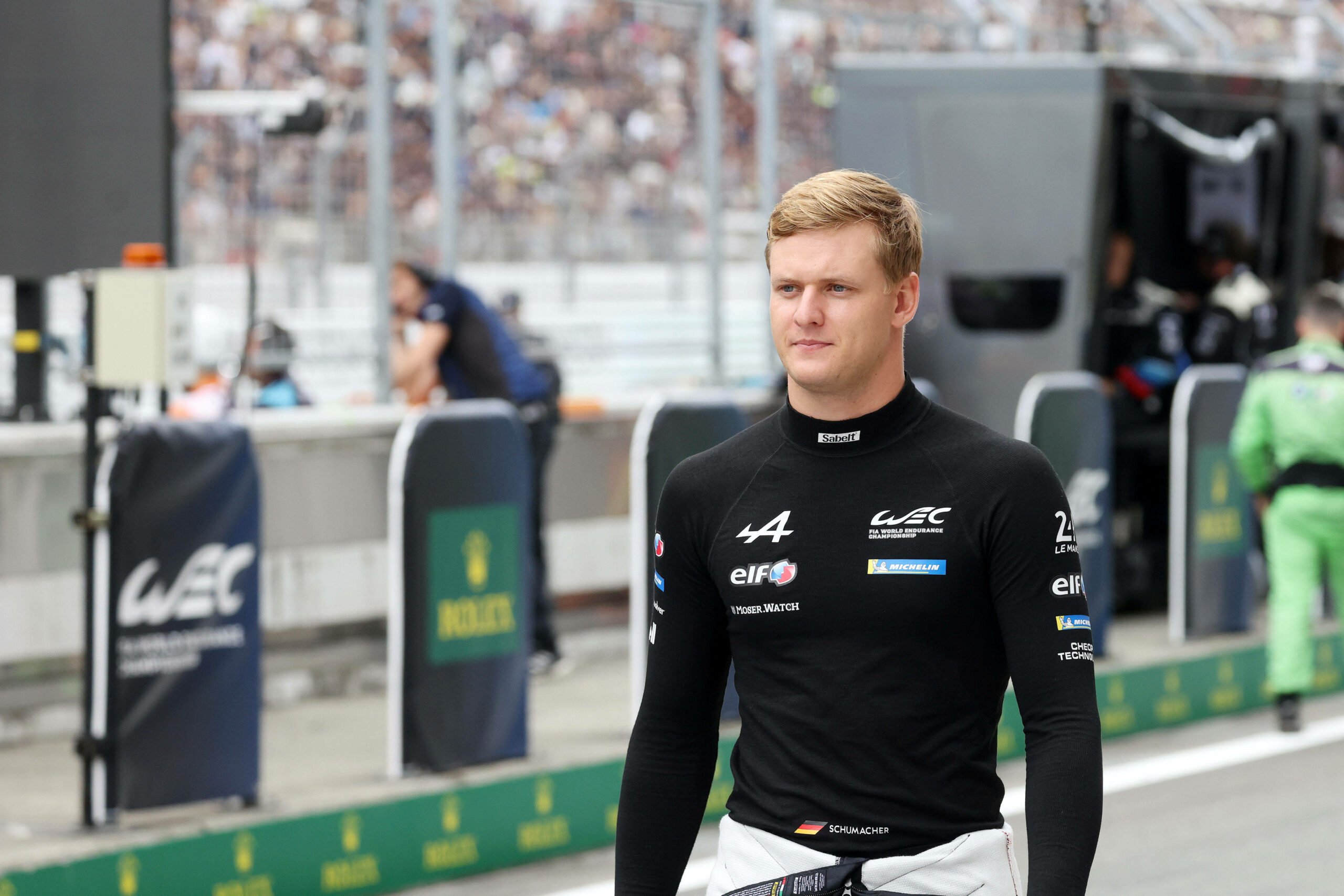 Mick Schumacher läuft bei einem Rennen durch eine Boxengasse.