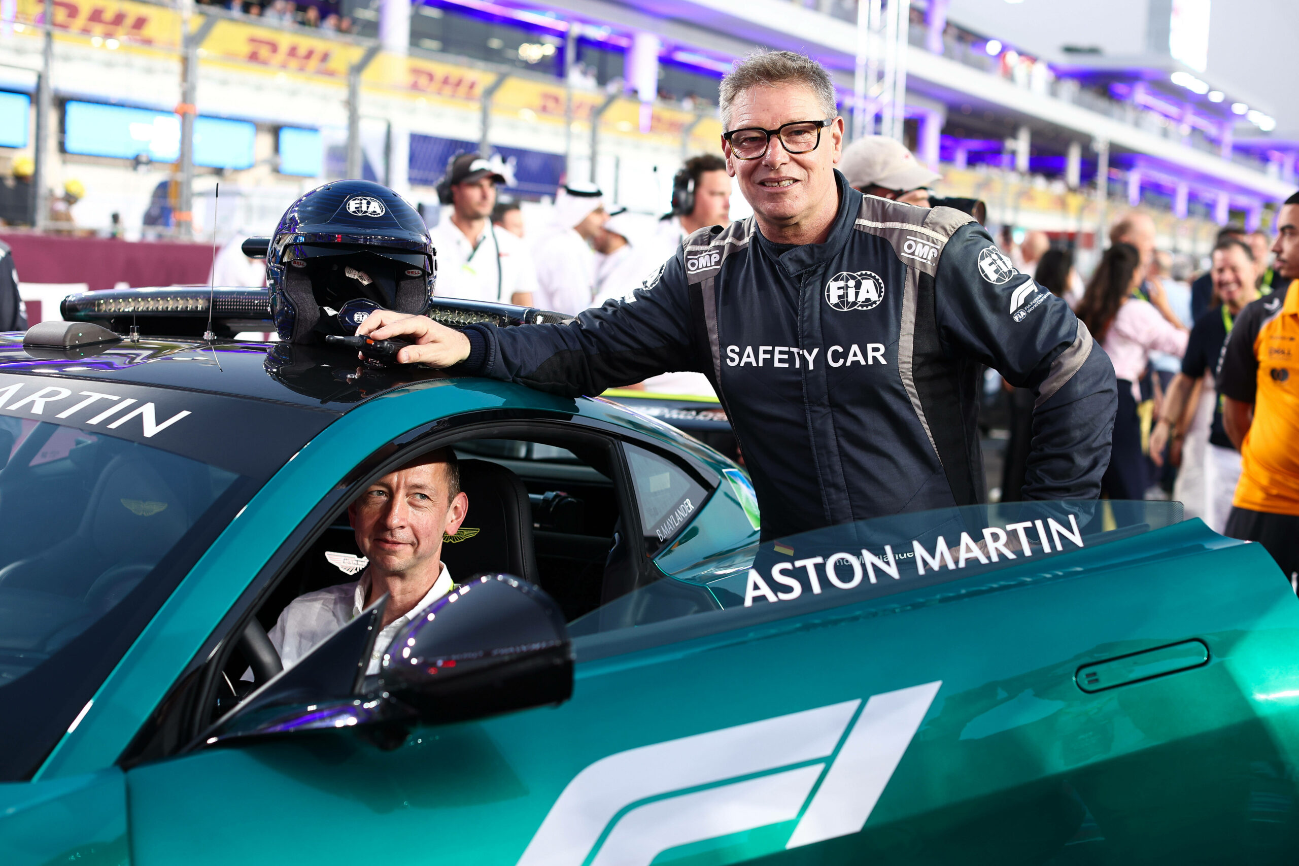 Bernd Mayländer posiert vor einem Aston Martin