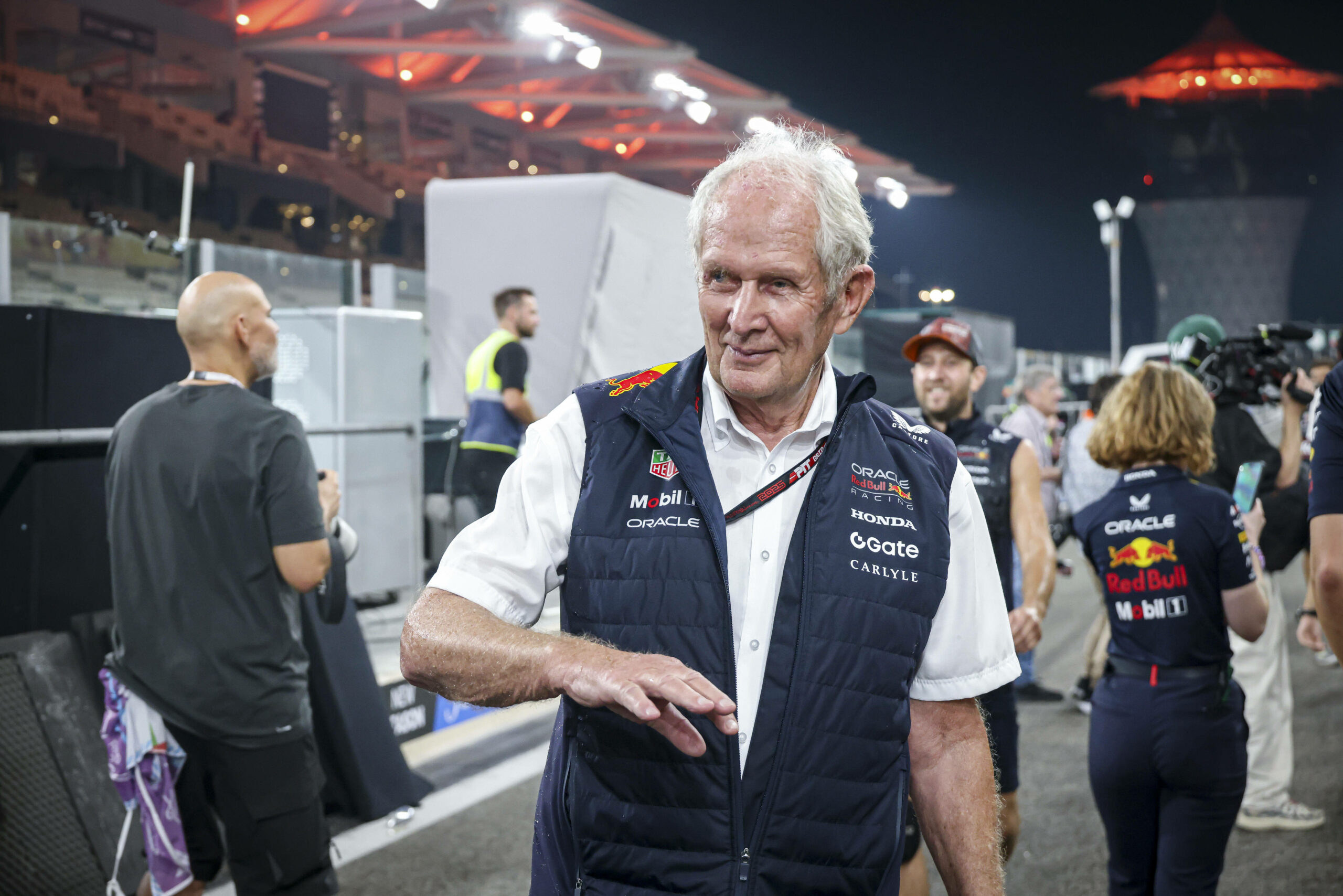 Helmut Marko steht in einem Boxenstopp und trägt eine Weste, erschaut zur Seite.