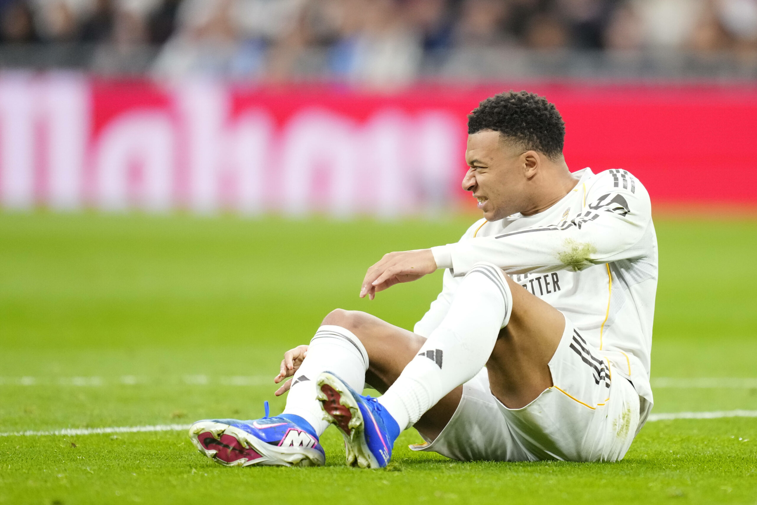 Kilian Mbappe sitzt mit schmerzverzerrtem Gesicht auf dem Platz