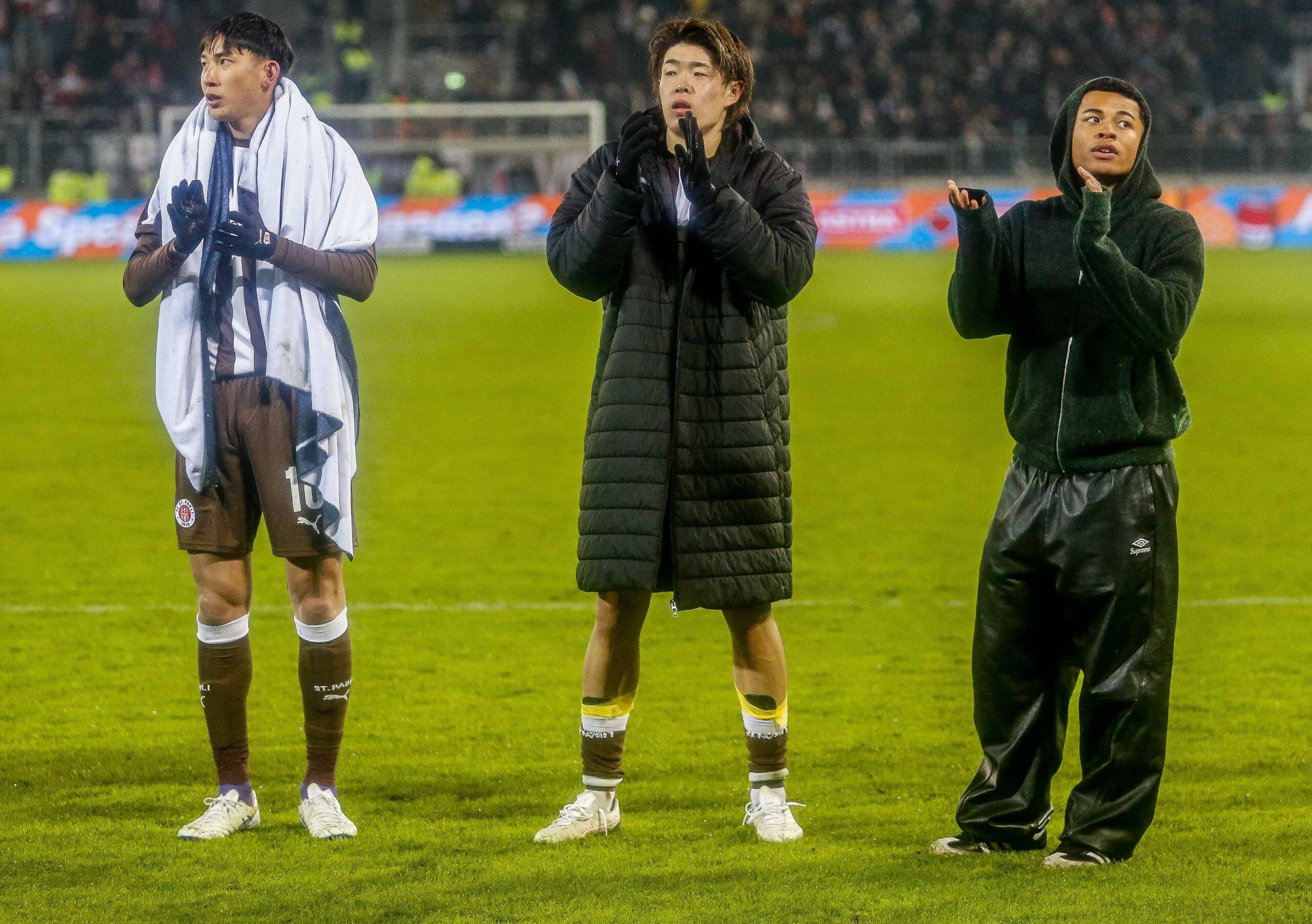 Taichi Hara, Tomoya Ando und Joel Chima Fujita klatschen vor den Fans