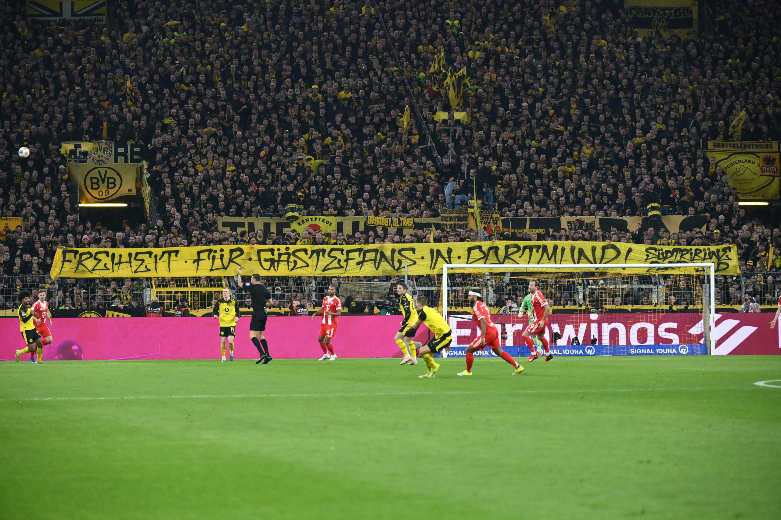 Dortmund-Fans halten im Spiel gegen den FC Bayern ein Banner mit der Aufschrift „Freiheit für Gästefans in Dortmund“ hoch.
