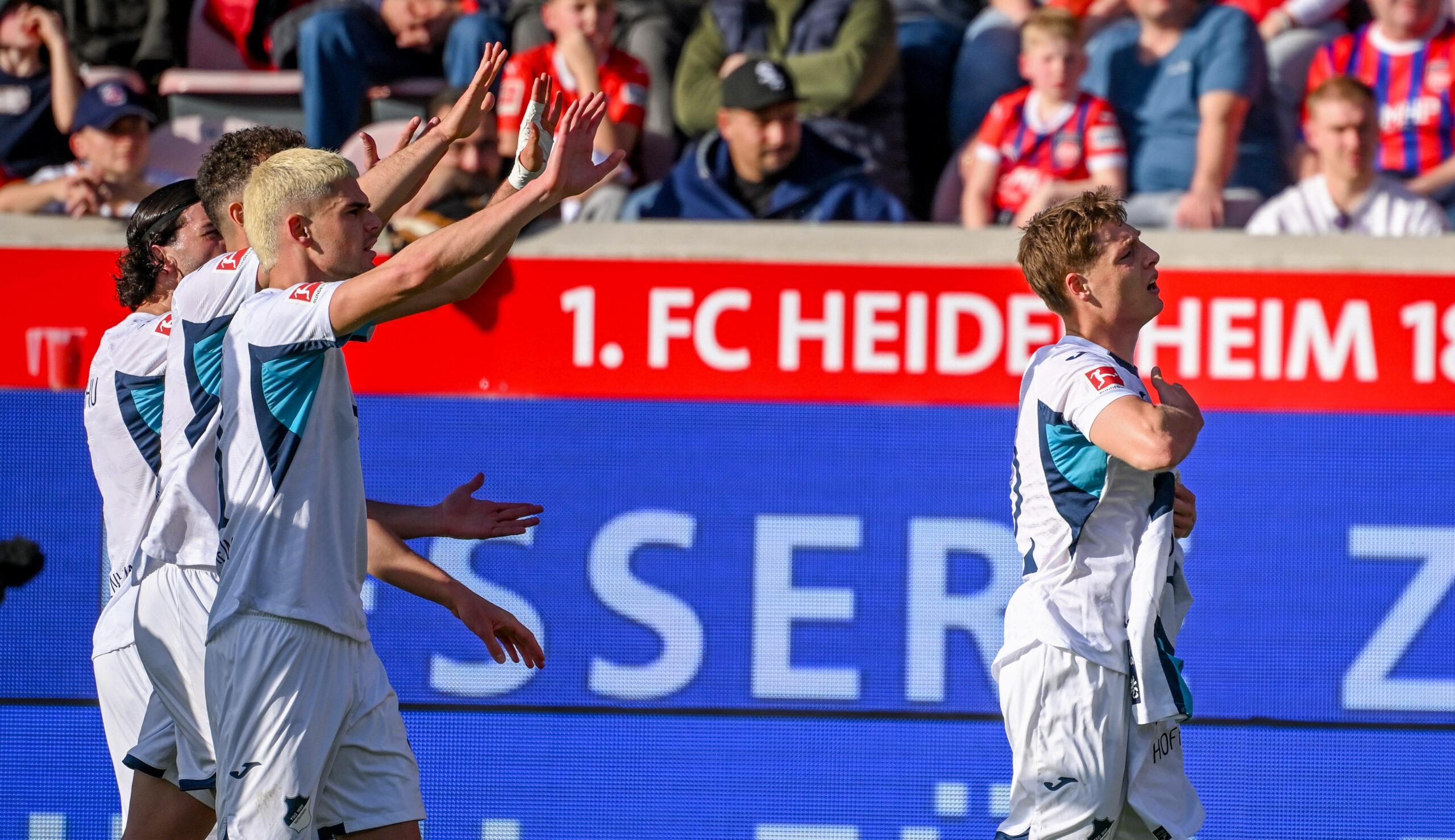 Hoffenheim.Profis jubeln bescheiden mit einem Bebou-Trikot in den Händen.