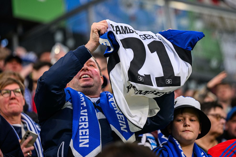 Ein HSV-Fan freut sich nach dem Sieg in Wolfsburg über das Trikot von Nicolai Remberg.