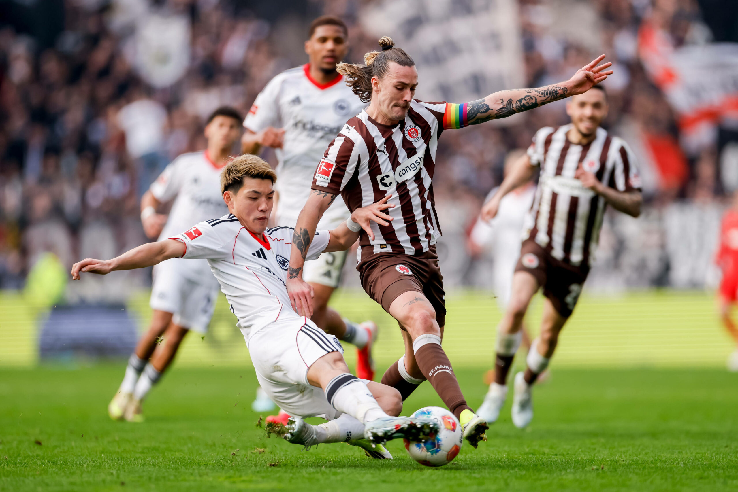 St. Pauli-Kapitän Jackson Irvine (r.) im Zweikampf mit Frankfurts Ritsu Doan.