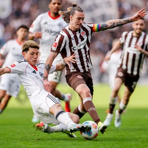 St. Pauli-Kapitän Jackson Irvine (r.) im Zweikampf mit Frankfurts Ritsu Doan.